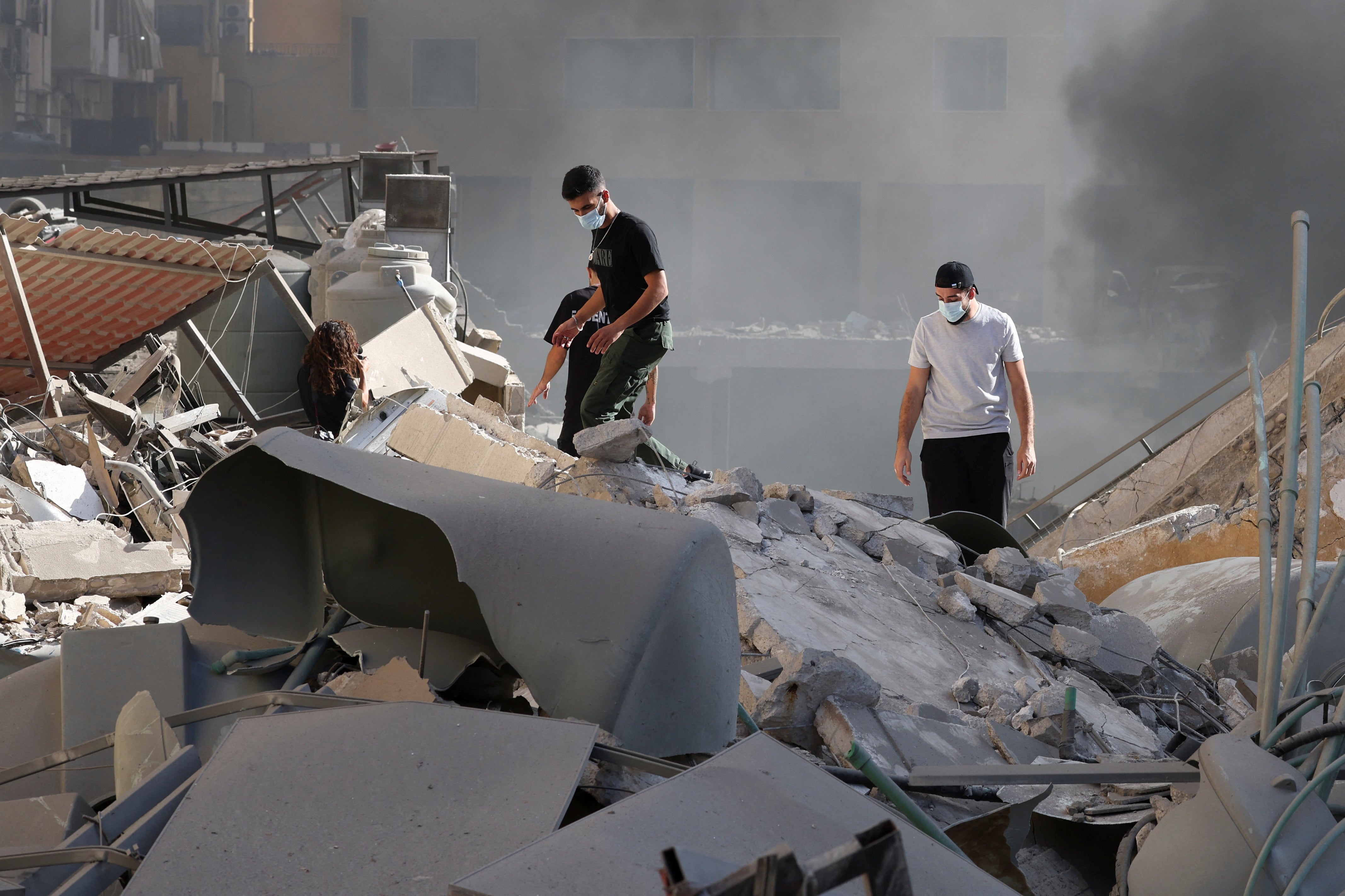 People look at the damage in the aftermath of Israeli strikes in Chiyah, Lebanon