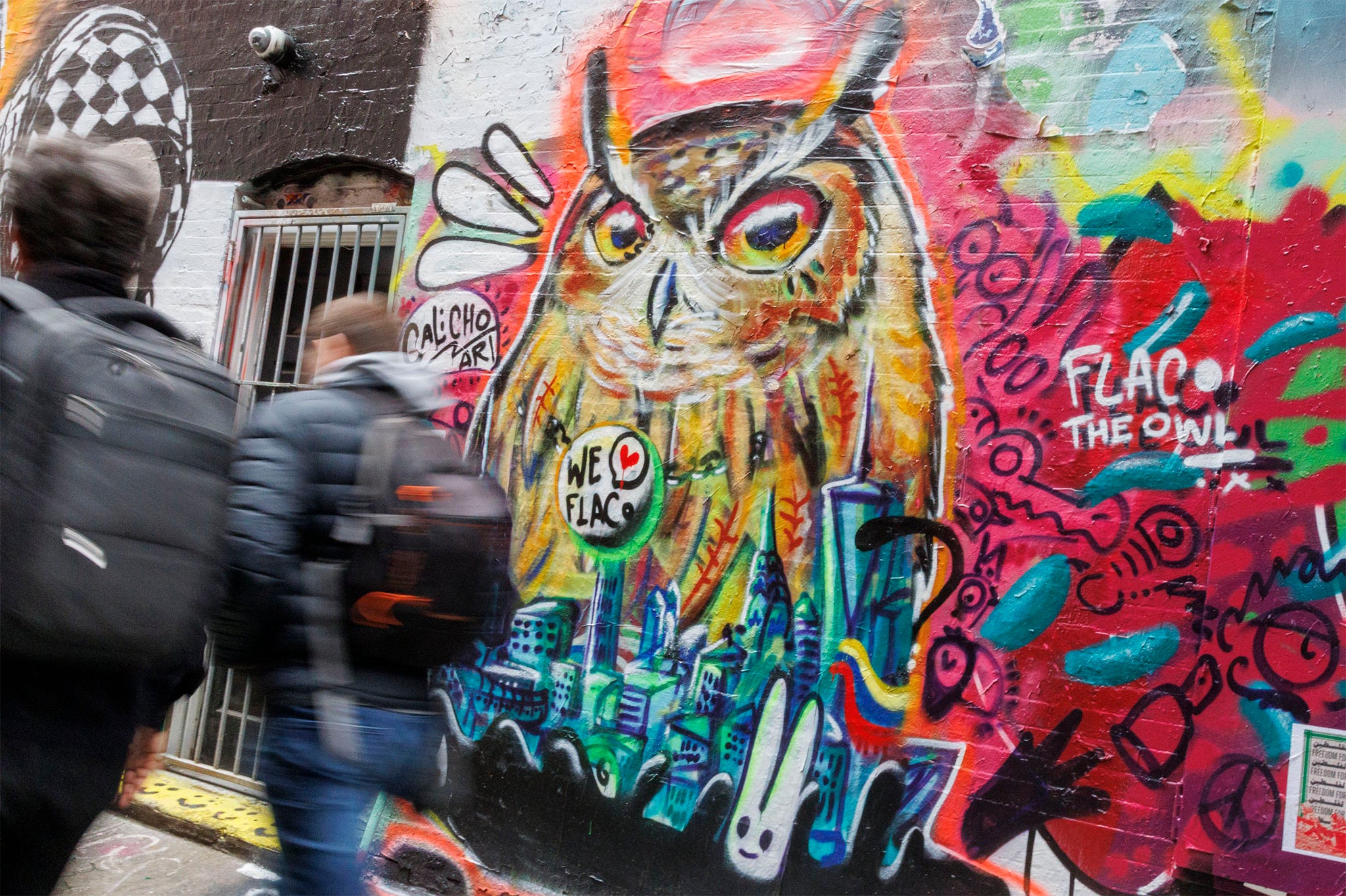 People walk past a mural honoring the late Flaco, the Central Park Zoo’s Eurasian eagle owl who spent a year flying around New York City after being set free and attracting thousands of fans.