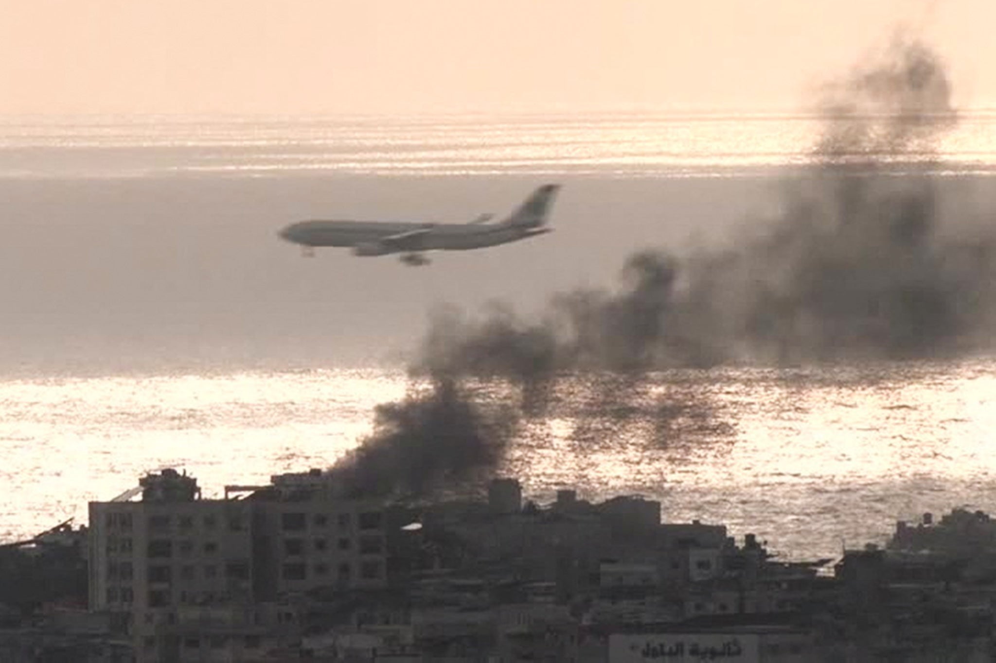 A flight (unidentified) lands at Beirut airport as smoke fills the air over the Lebanese capital