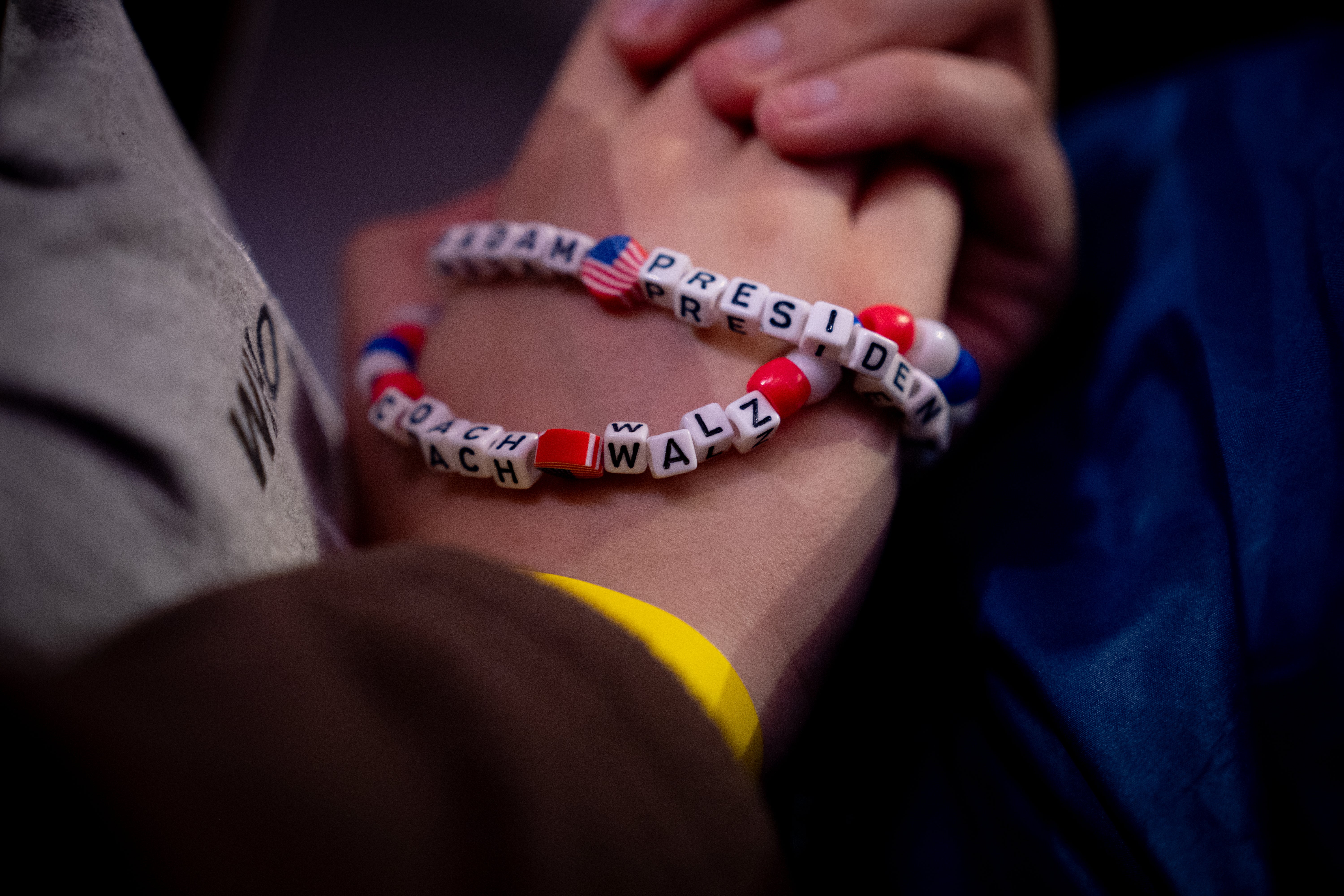 A woman in the audience wears “Madame President” and “Coach Walz” bracelets as Democratic vice presidential nominee Minnesota Gov. Tim Walz speaks at a rally in Pennsylvania.