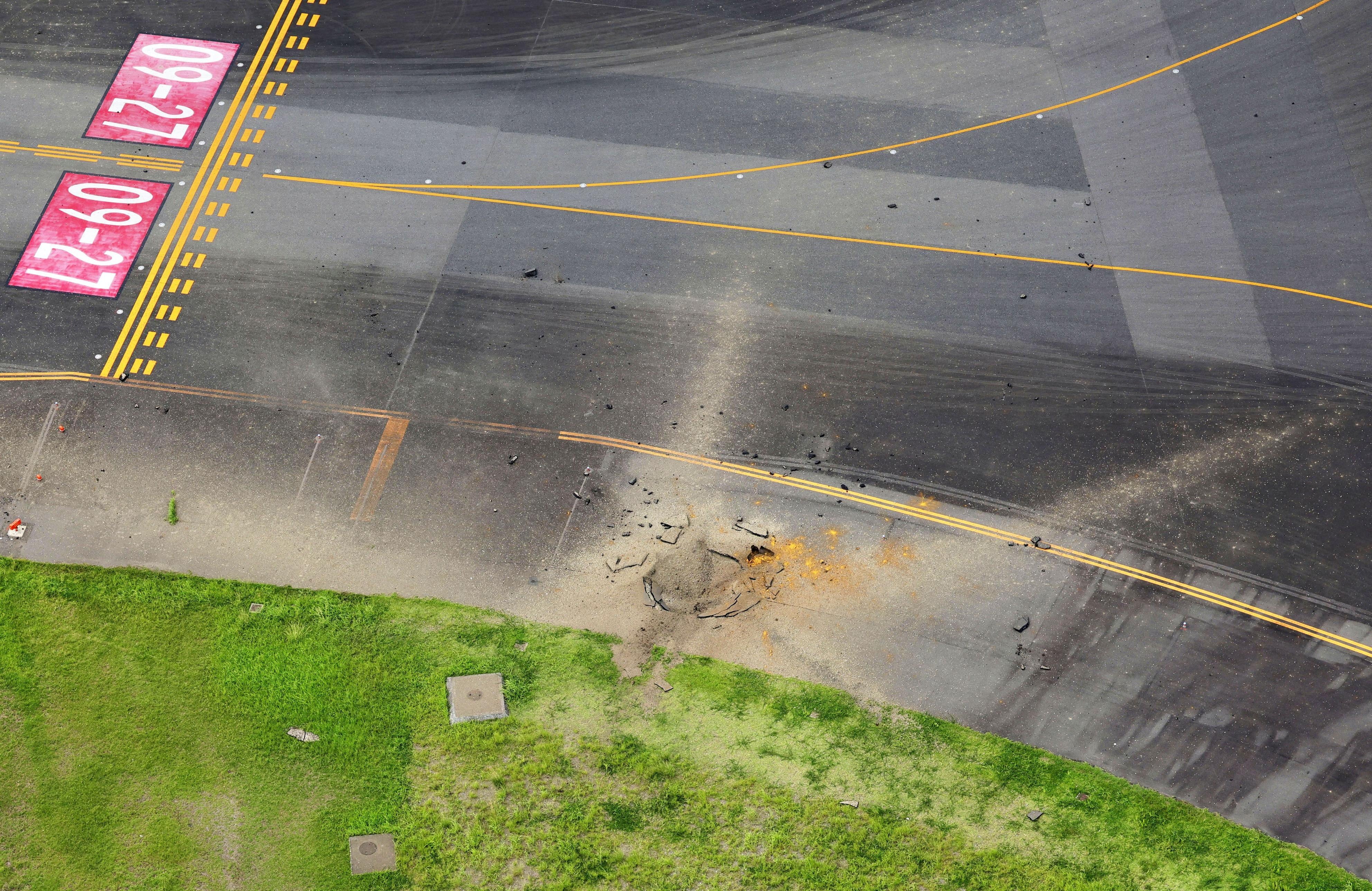 Aerial view taken from a helicopter shows a crater from an explosion after likely WW2-era bomb exploded, on a taxiway at Miyazaki Airport