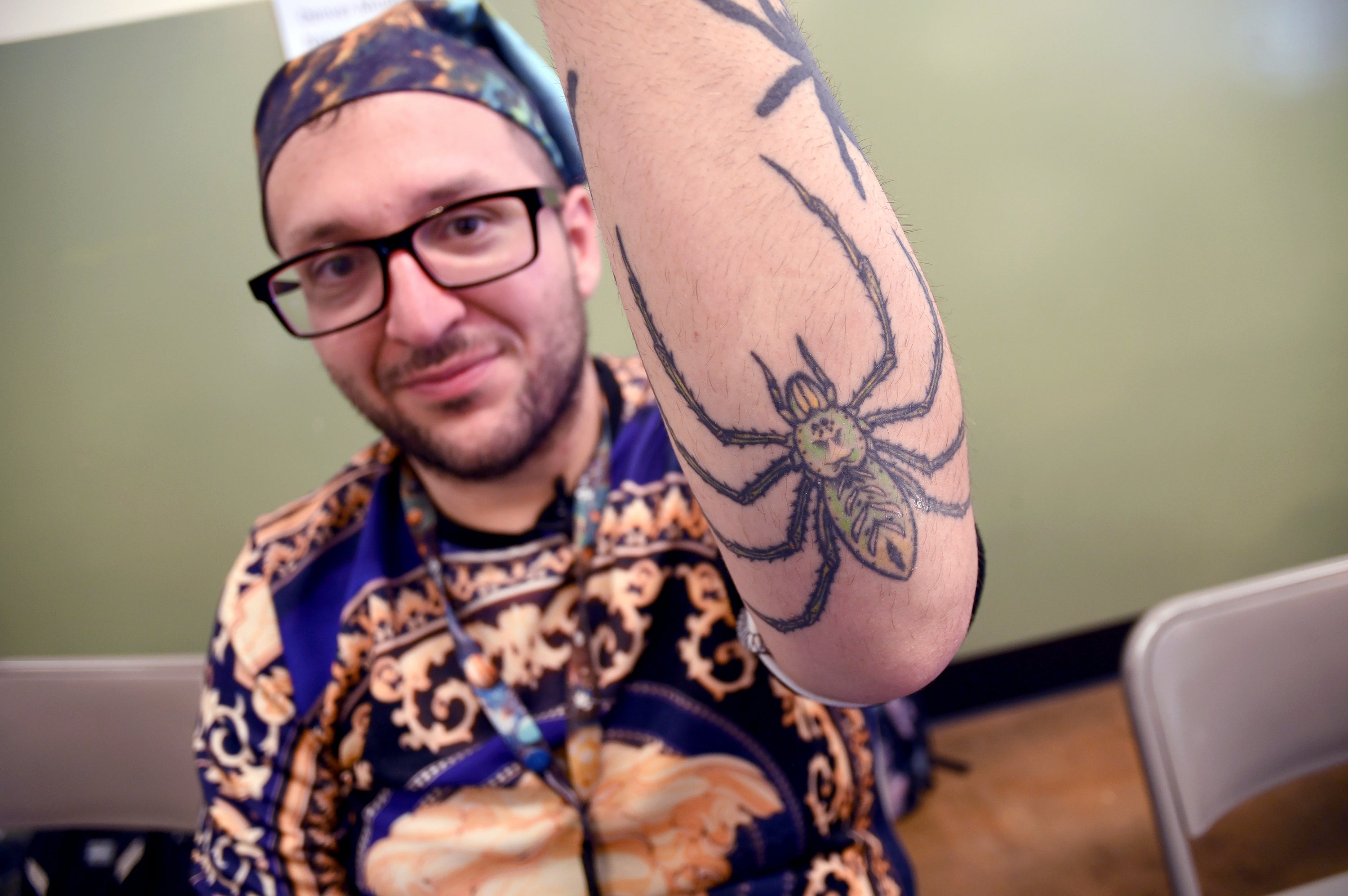 Goran Shikak, an arachnology graduate student at The University of Colorado Denver, shows off his spider tattoos