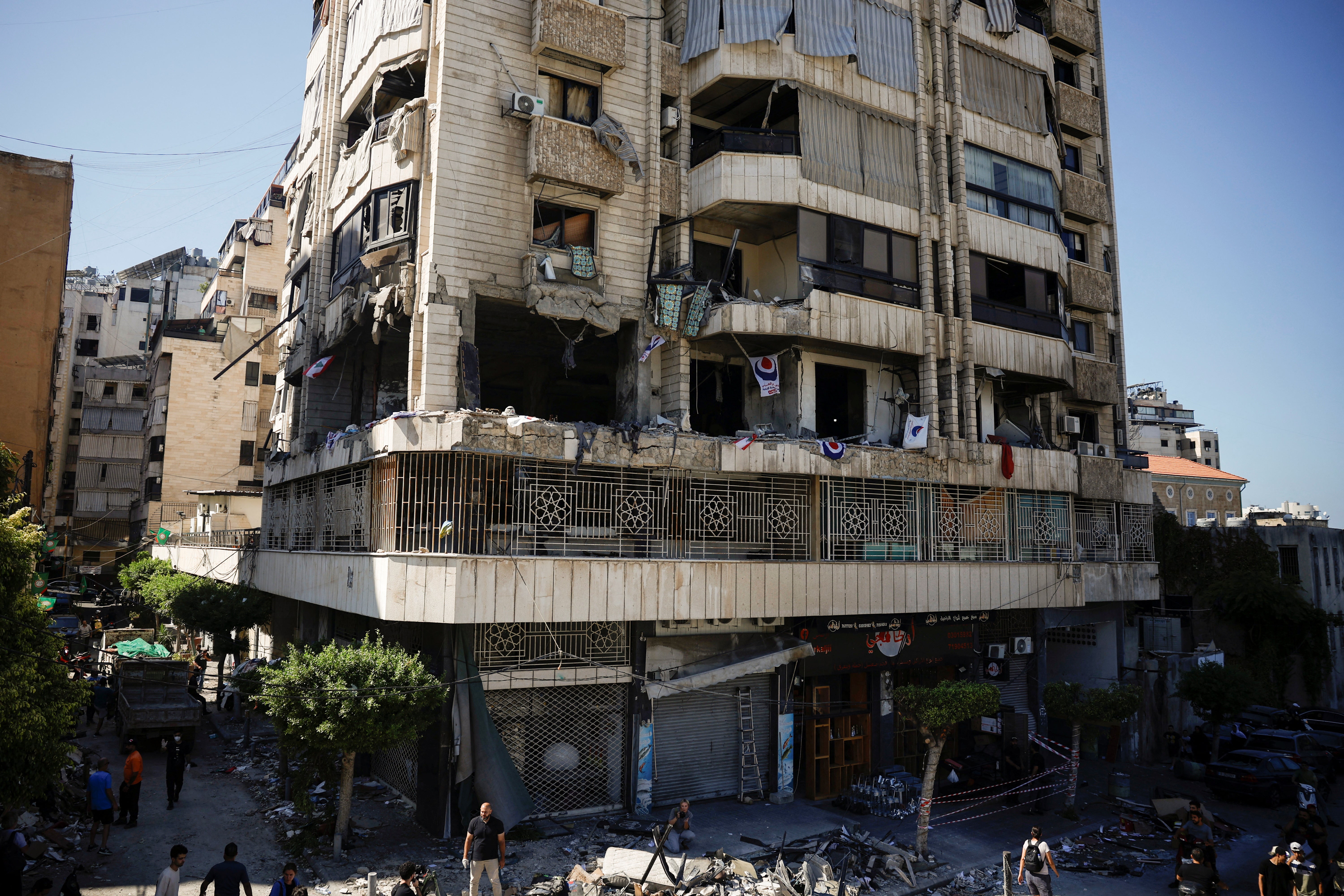 People look at a damaged building at the site of an Israeli strike on central Beirut’s Bachoura neighbourhood