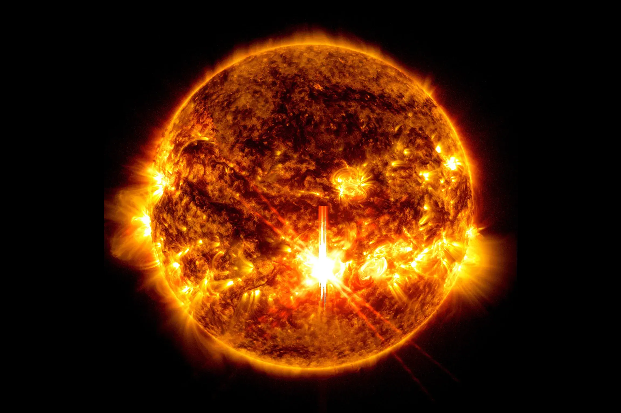 NASA’s Solar Dynamics Observatory captured this image of a solar flare — seen as the bright flash in the center – on Oct. 3, 2024. The image shows subsets of extreme ultraviolet light that highlight the extremely hot material in flares and which are colorized in red and gold