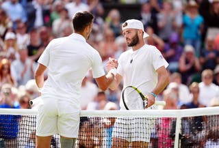 Jacob Fearnley, right, shakes hands with Novak Djokovic at Wimbledon