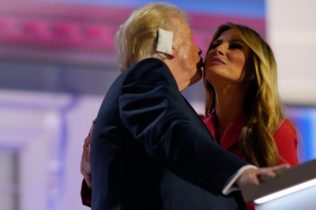 <p>Donald Trump kisses Melania Trump on stage at the Republican National Convention</p>