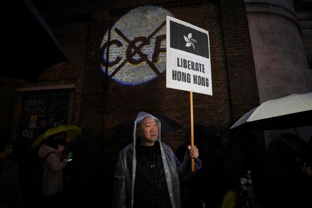 <p>Anti-China protester from Hong Kong holds a placard during a protest to mark the 75th National Day of the People's Republic of China in London, Tuesday</p>