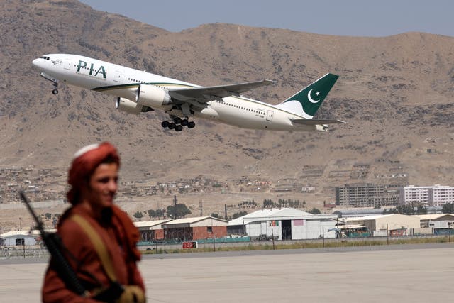 <p>A Taliban fighter stands guard as a Pakistan International Airlines plane takes off</p>