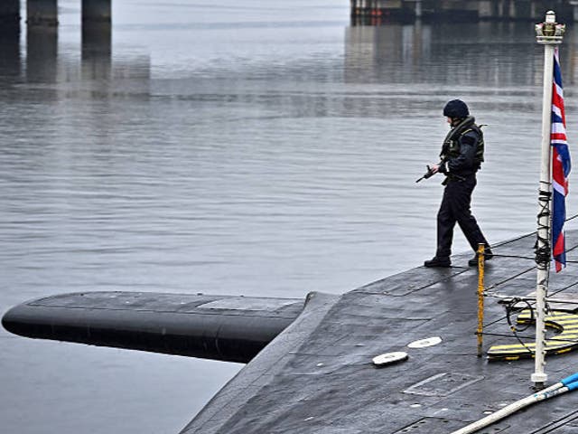 <p>Royal Navy security personnel stand guard on HMS Vigilant at Her Majesty's Naval Base, Clyde on January 20, 2016 in Rhu, Scotland</p>