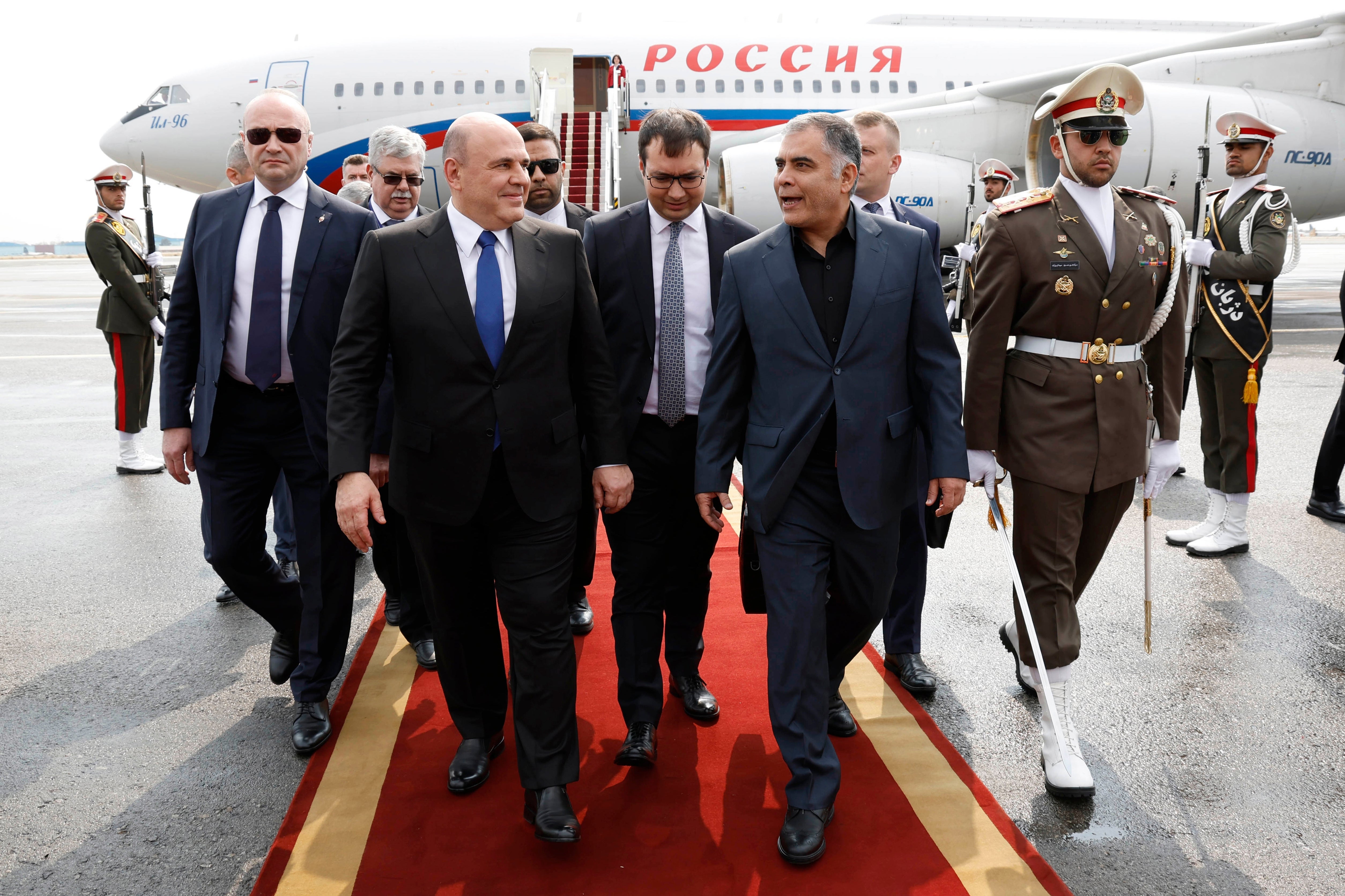 Russian Prime Minister Mikhail Mishustin, left, is welcomed by Iranian Oil Minister Mohsen Paknejad upon arrival at the Mehrabad International Airport in Tehran last month