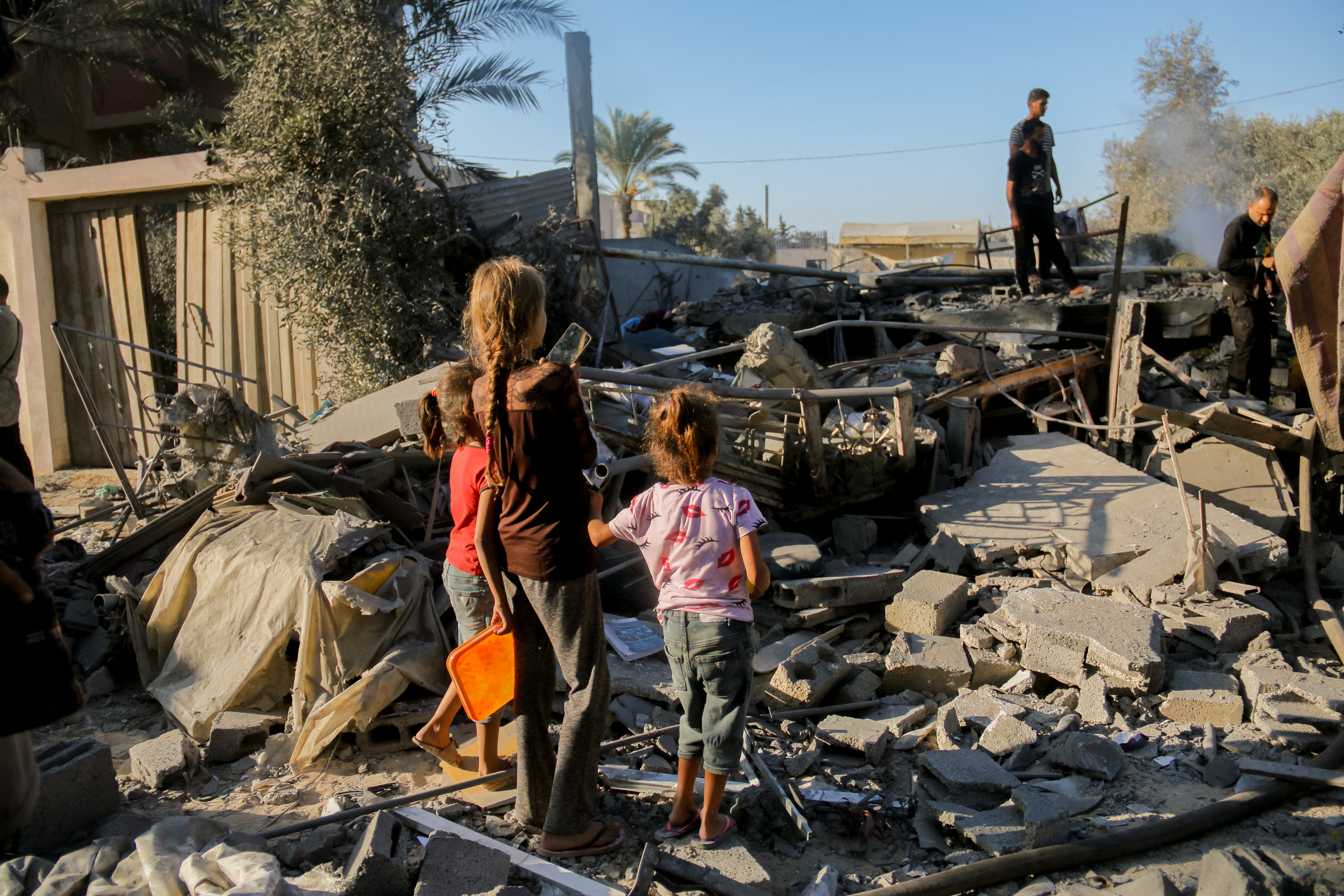 Palestinian children amongst debris following Israeli airstrike in Deir al-Balah, central Gaza on Friday