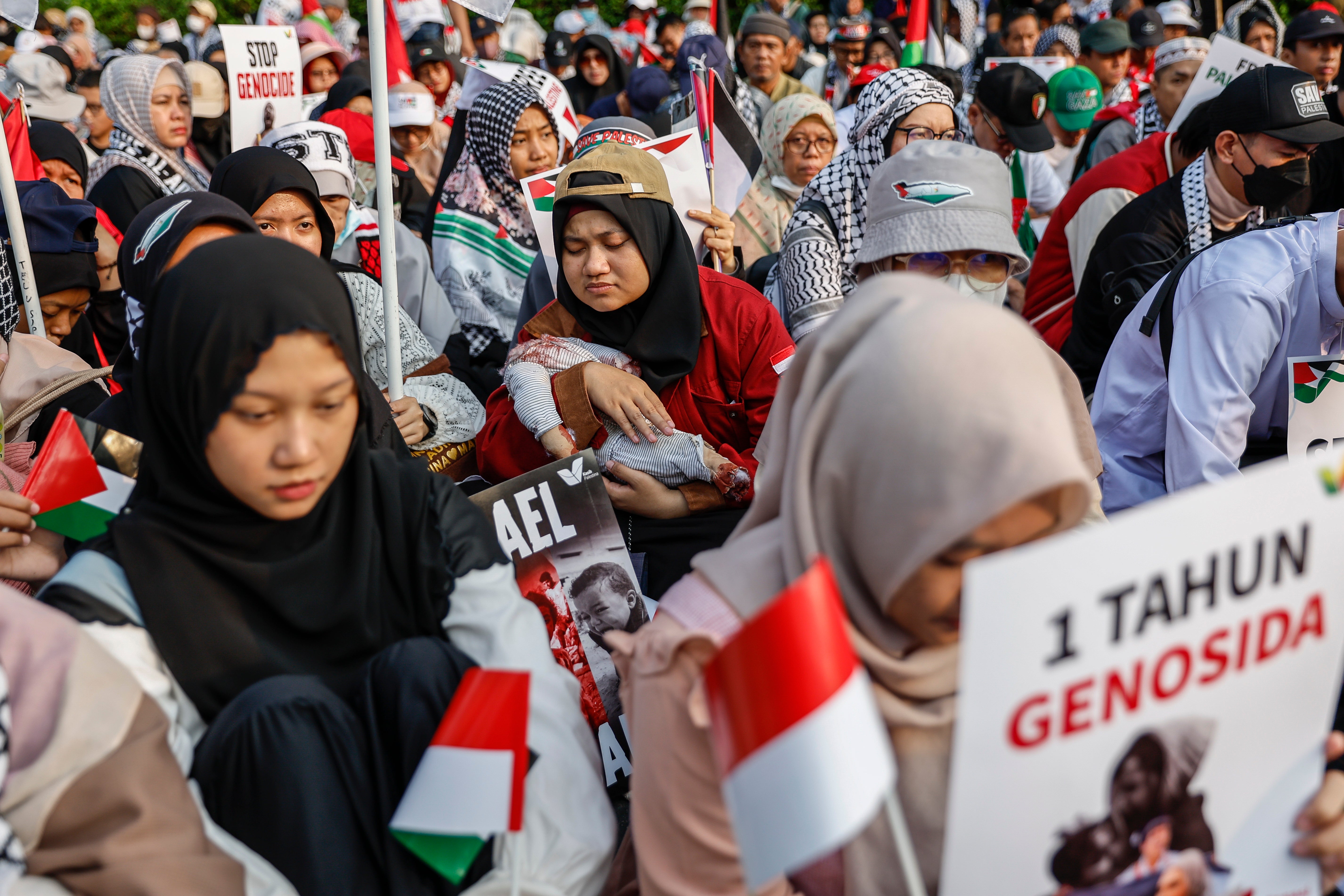 Protester carries headless doll symbolising dead Palestinian children during a rally to mark one year of Israel’s war on Gaza outside the US embassy in Jakarta, Indonesia