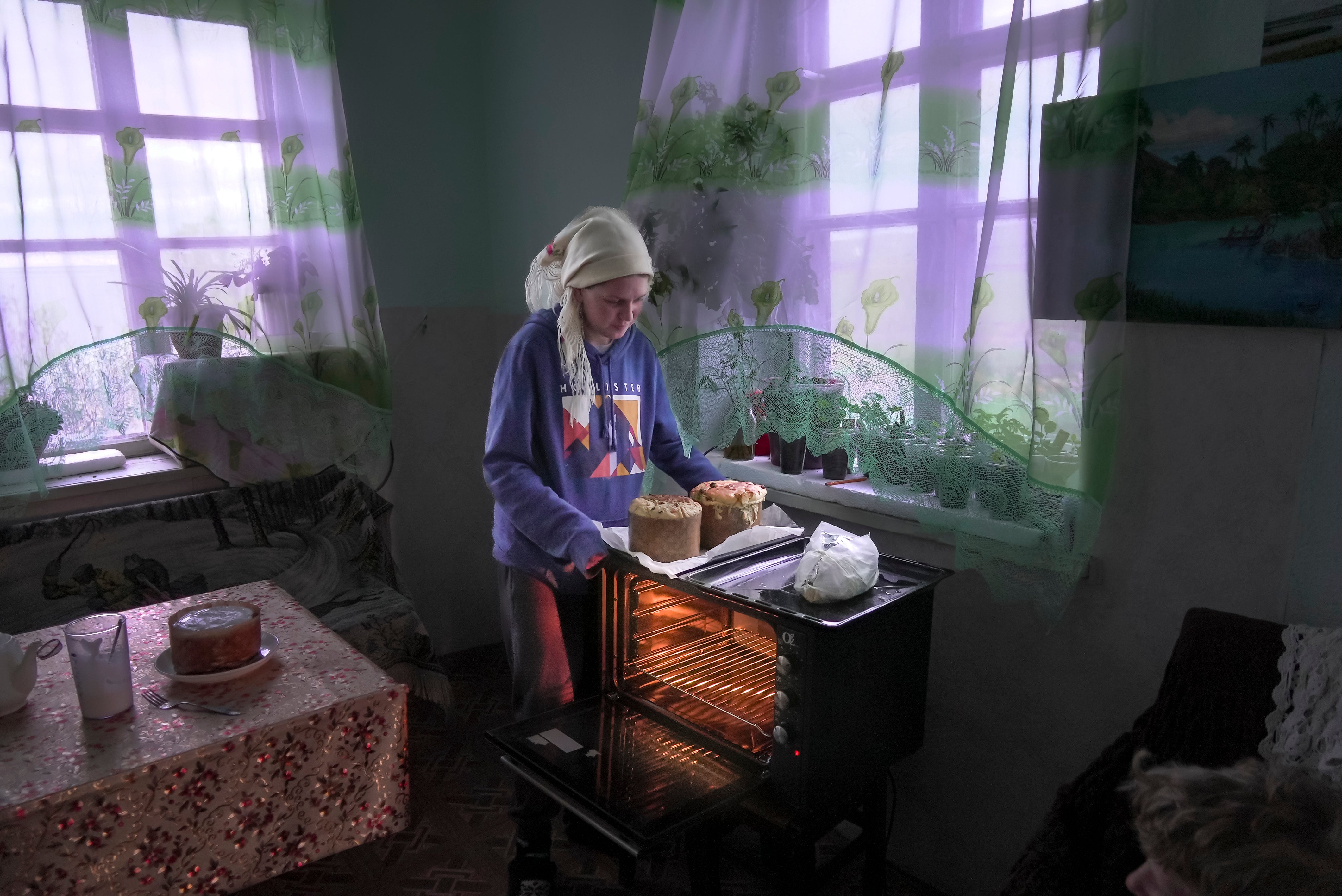 Daria Strukova takes Easter cakes off a stove in her family home in the remote mountain village of Orlovka