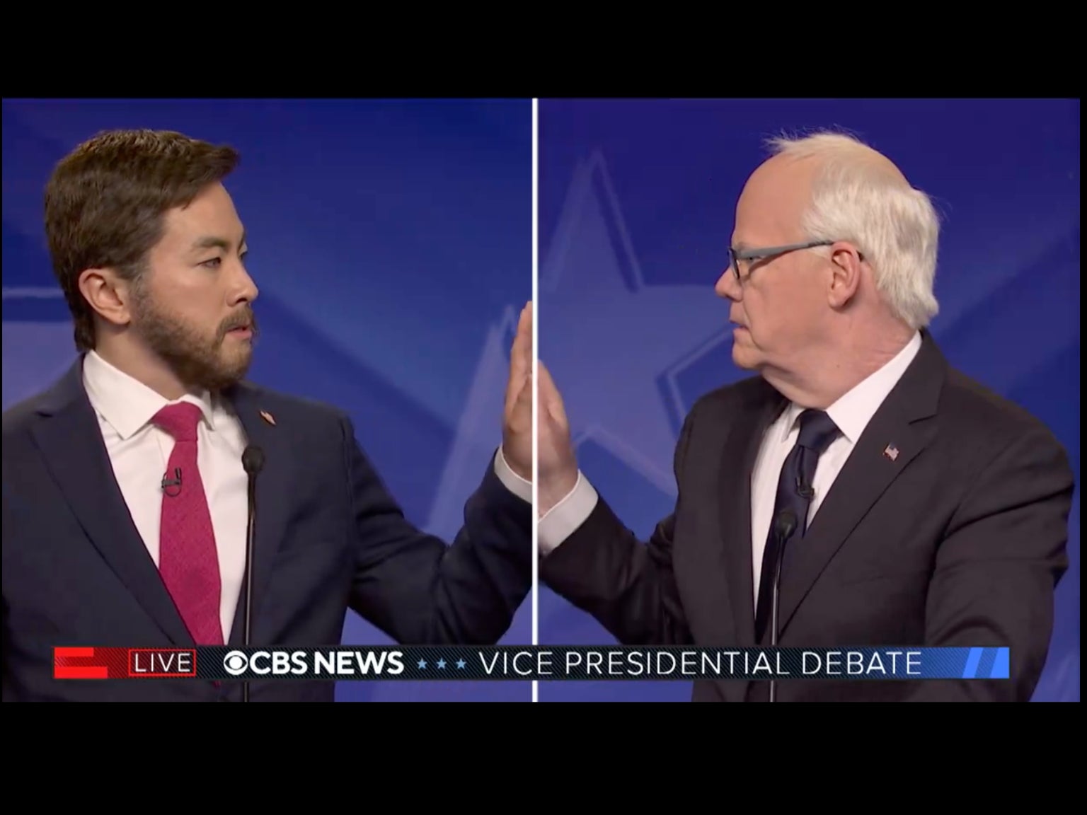 Bowen Yang’s JD Vance, left, and Jim Gaffigan’s Tim Walz, right, share a tender moment during a parody of the vice presidential debate on Saturday Night Live’s cold open on October 5, 2024