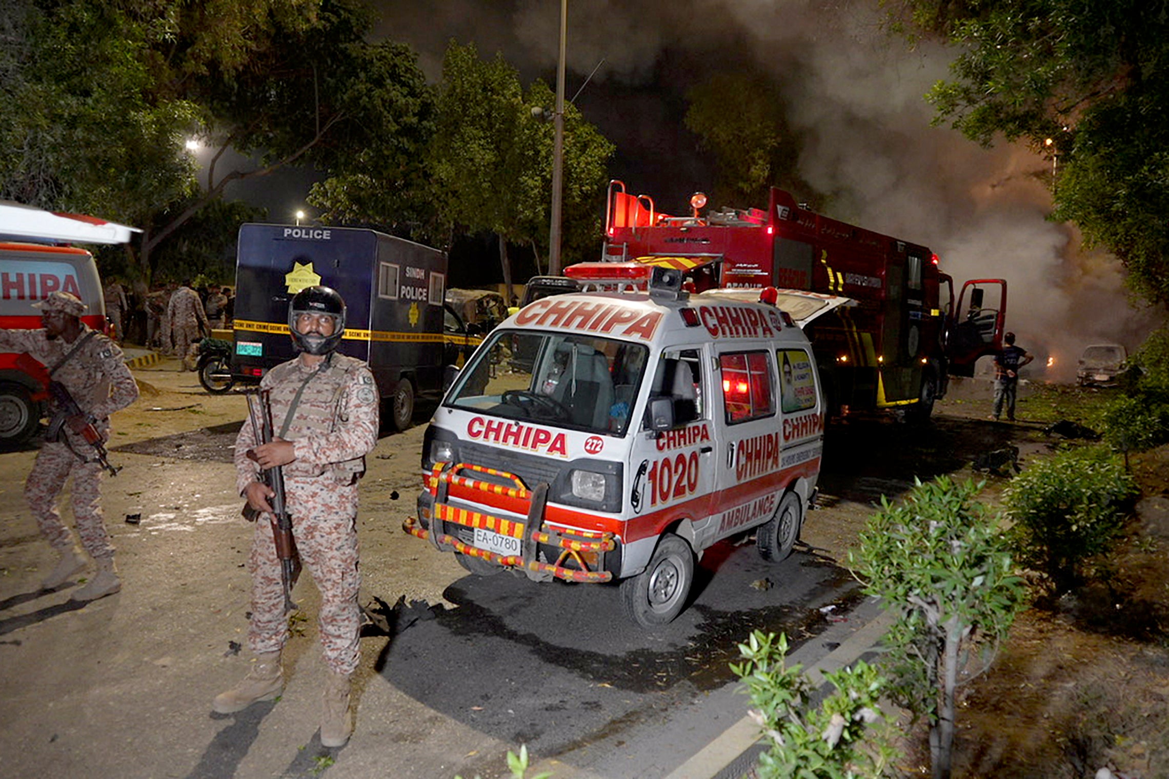 Paramilitary soldiers stand guard close to the site of an explosion that caused injuries and destroyed vehicles at outside the Karachi airport, Pakistan