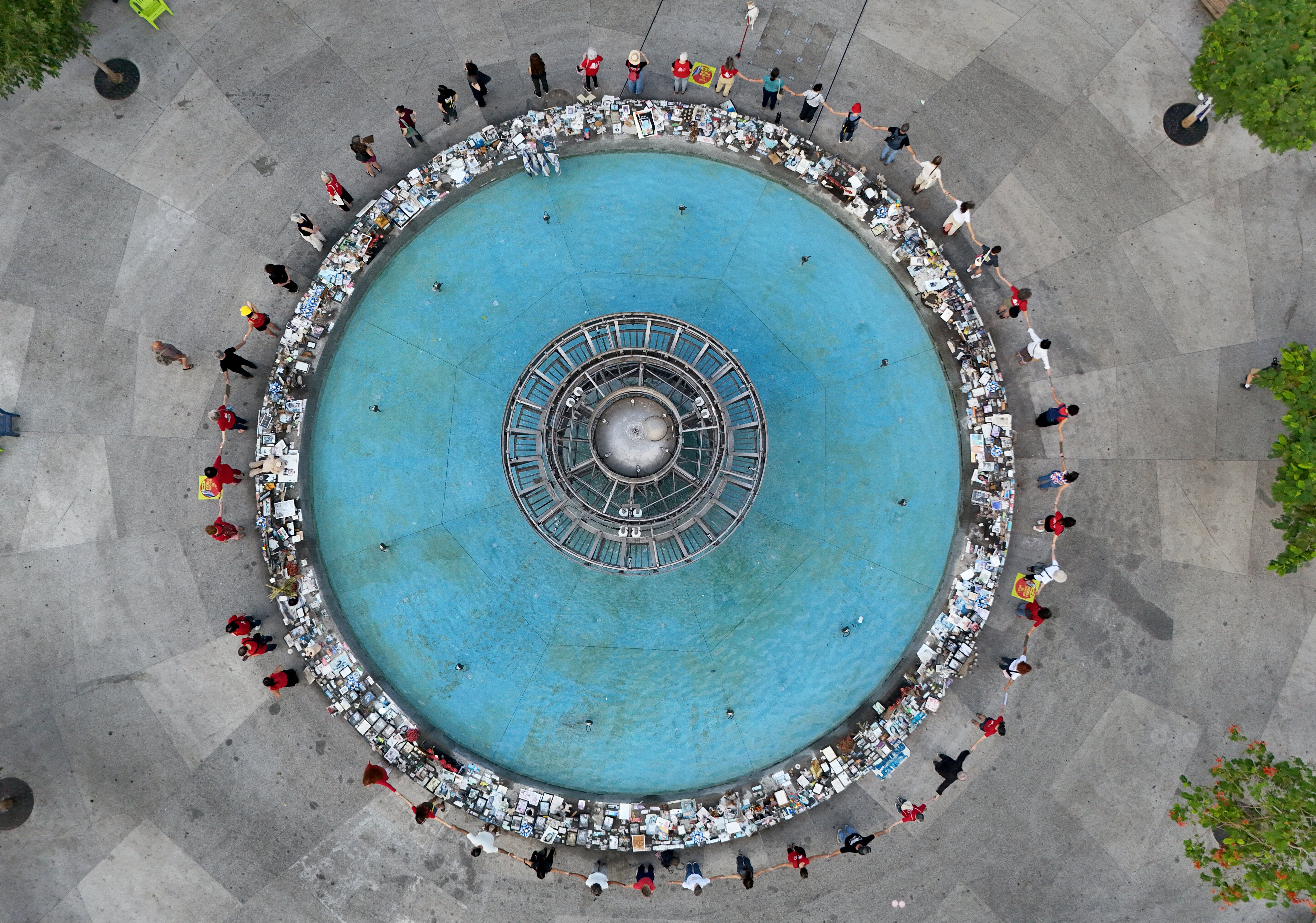 This aerial view shows people holding hands at a memorial event marking the one-year anniversary of the Hamas attack in southern Israel, in Tel Aviv