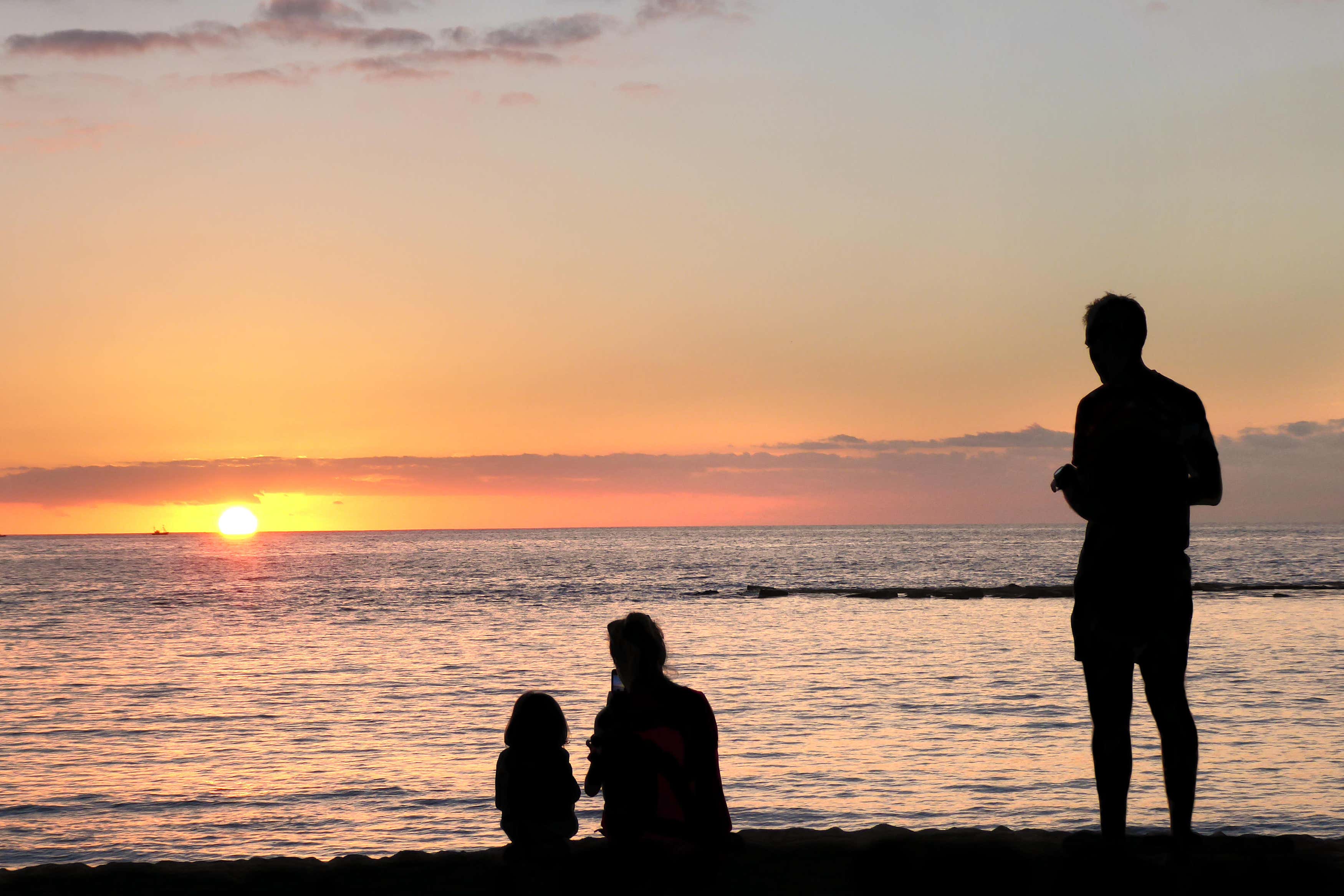 A family watching sunset on a beach in Tenerife, Spain