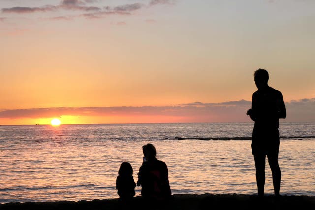 <p>A family watching sunset on a beach in Tenerife, Spain
</p>