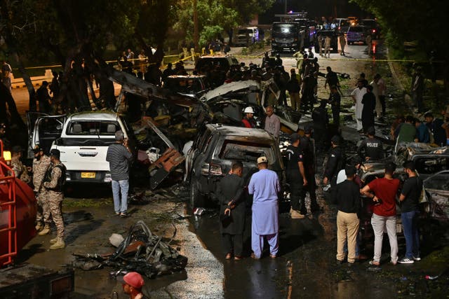 <p>Security officials examine at the site of an explosion which occured near Karachi airport in Karachi</p>