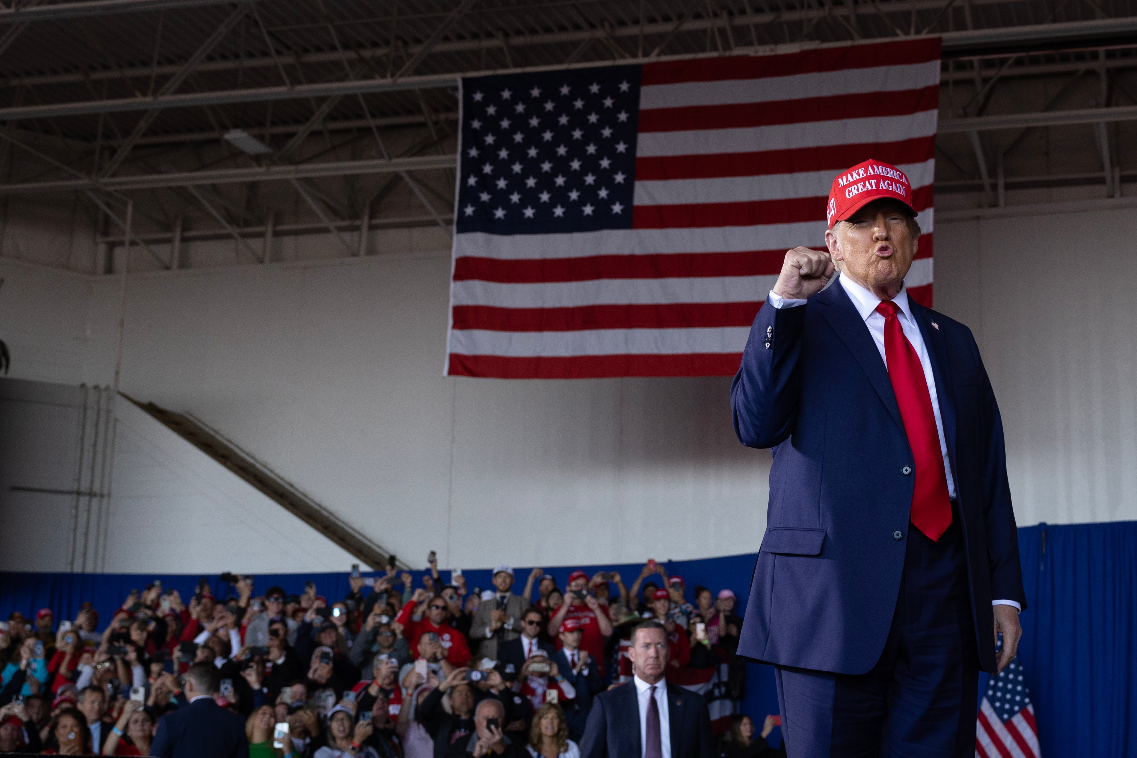 Trump pumps his fist while speaking at a rally at Dodge County Airport in Juneau, Wisconsin, on Sunday