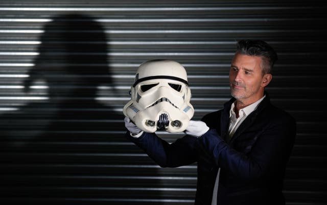 <p>Propstore CEO Stephen Lane holds a screen-matched Stormtrooper (Sandtrooper) helmet from the ‘Move Along, Move Along’ scene from the 1977 film ‘Star Wars: A New Hope’ (estimate £250,000 - £500,000) during a photo call at the Propstore in Rickmansworth, Hertfordshire, ahead of their Entertainment Memorabilia Live Auction which takes place over four days from November 14</p>