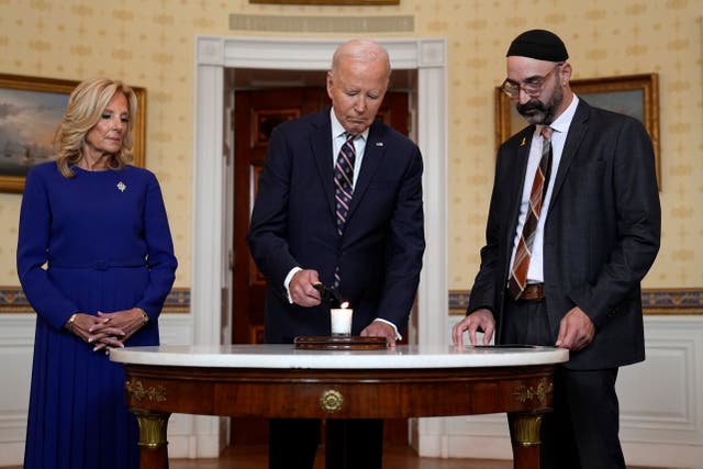 <p>President Joe Biden standing with first lady Jill Bidenb and Rabbi Aaron Alexander of the Adas Israel Congregation, lights a memorial candle in the Blue Room of the White House to mark the one-year anniversary of the Hamas attack on Israel that left about 1,200 people dead</p>