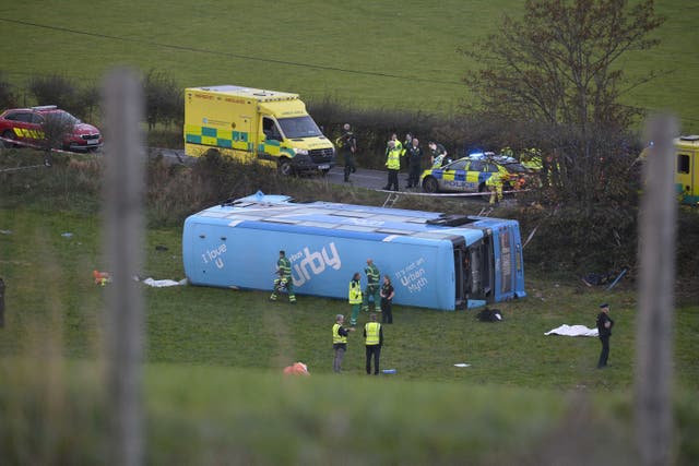 <p>Emergency workers at the scene of a school bus crash on the Ballyblack Road East near Carrowdore in Northern Ireland on Monday afternoon (Mark Marlow/PA)</p>