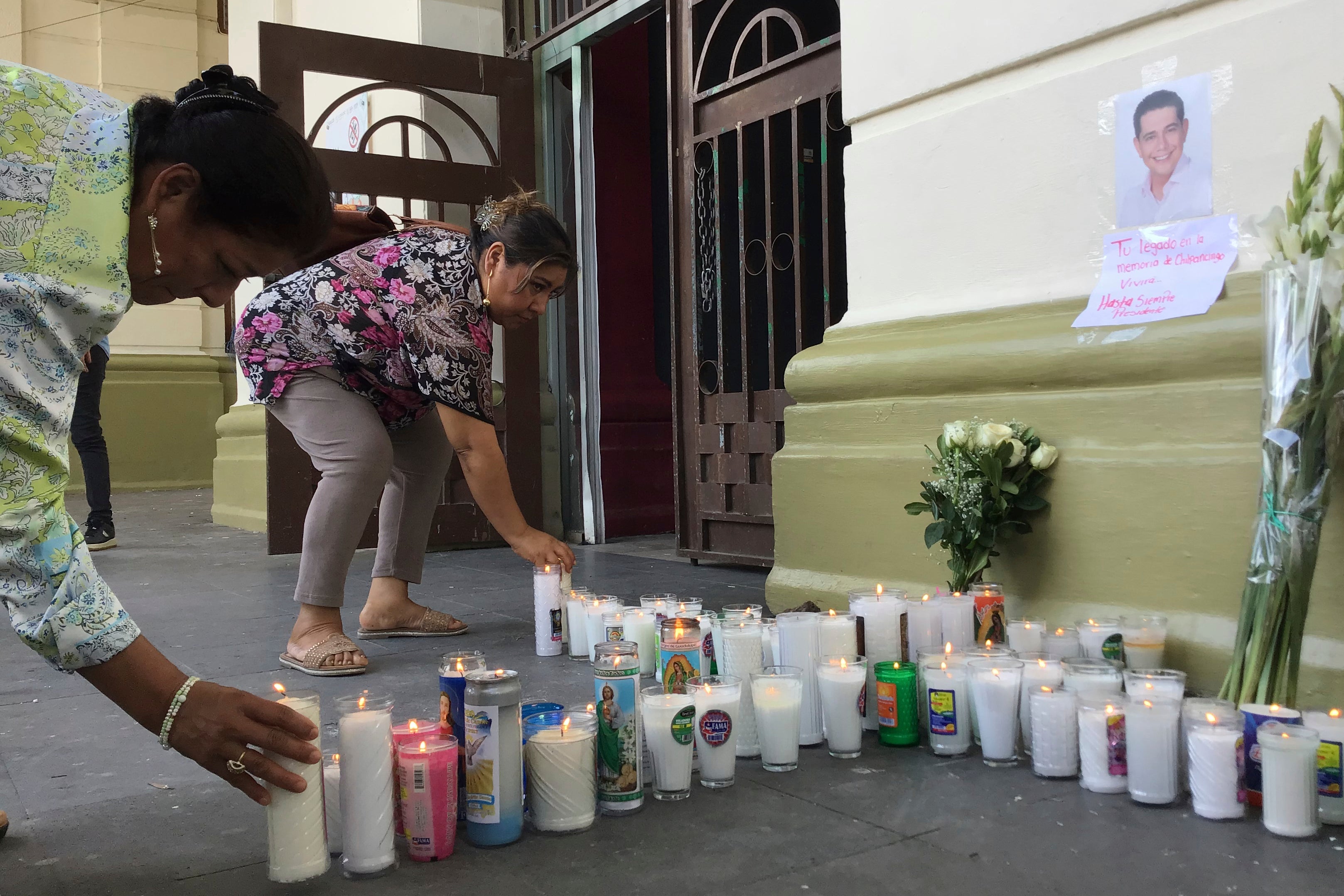 Supporters of slain Mayor Alejandro Arcos place candles and flowers at the entrance of the municipal building one week after he took office in Chilpancingo, Mexico