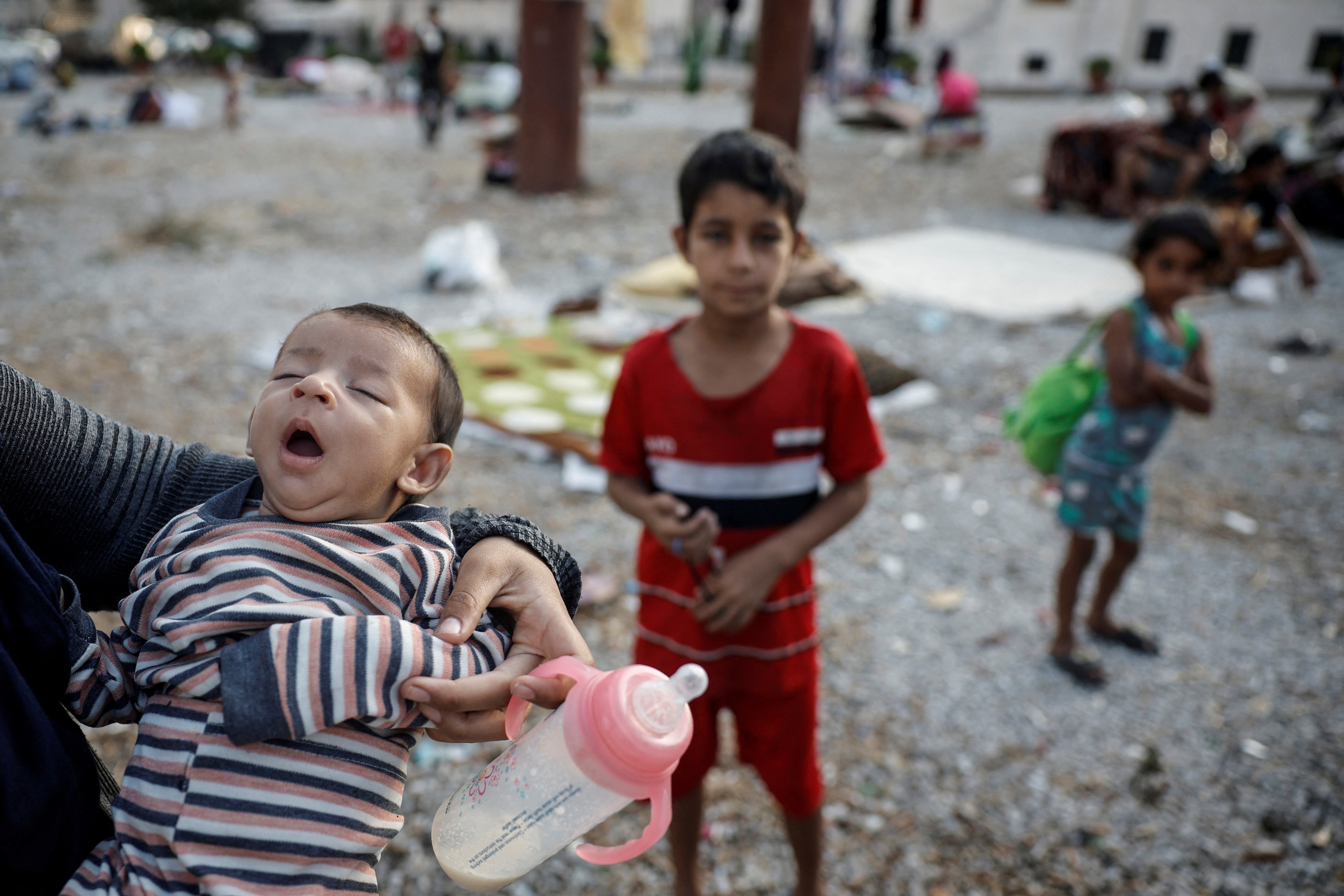 A mother holds her infant as two young children watch on in the Lebanese capital of Beirut