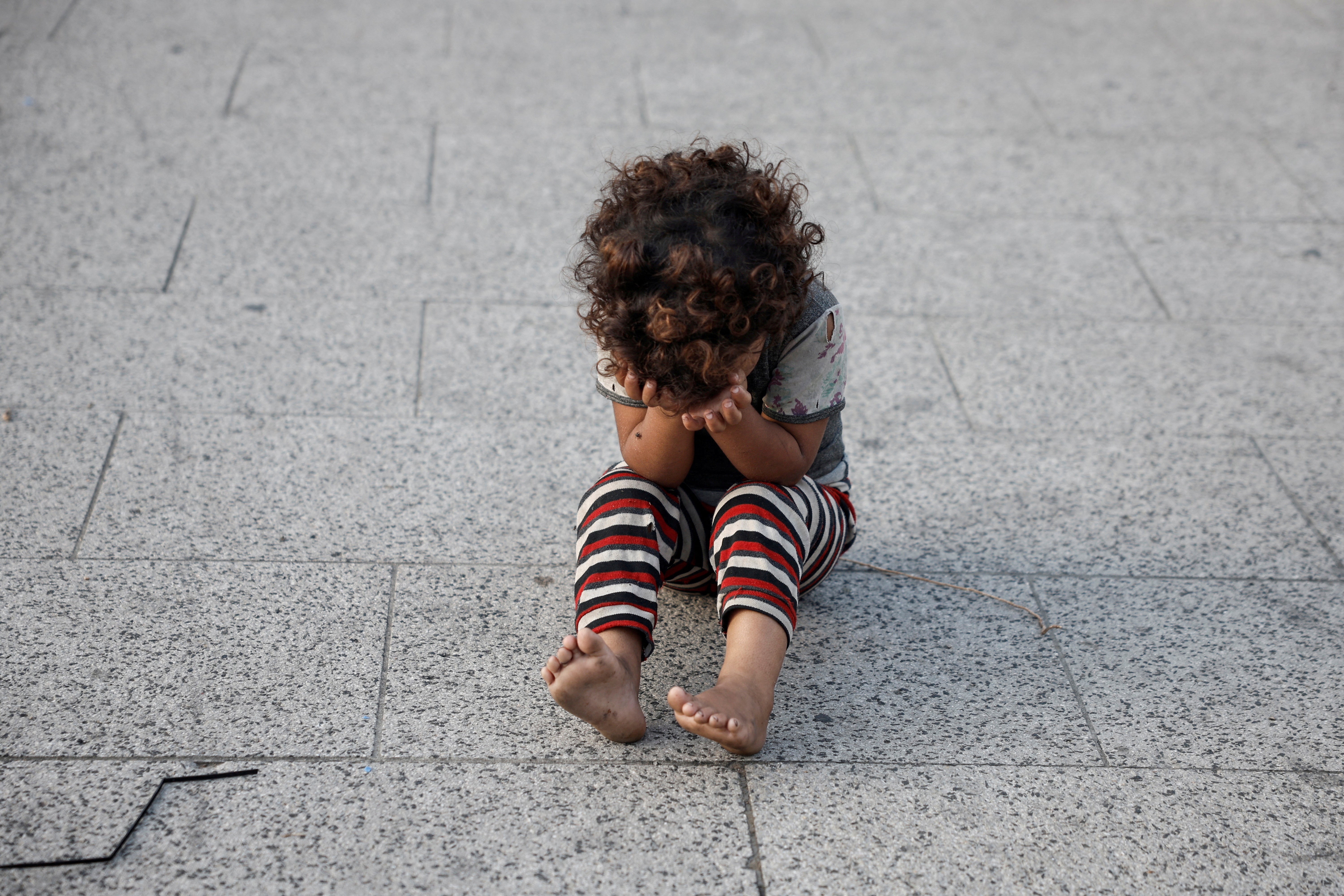 A displaced Lebanese child sits with their head in their hands amid Israel’s ongoing offensive against Hezbollah