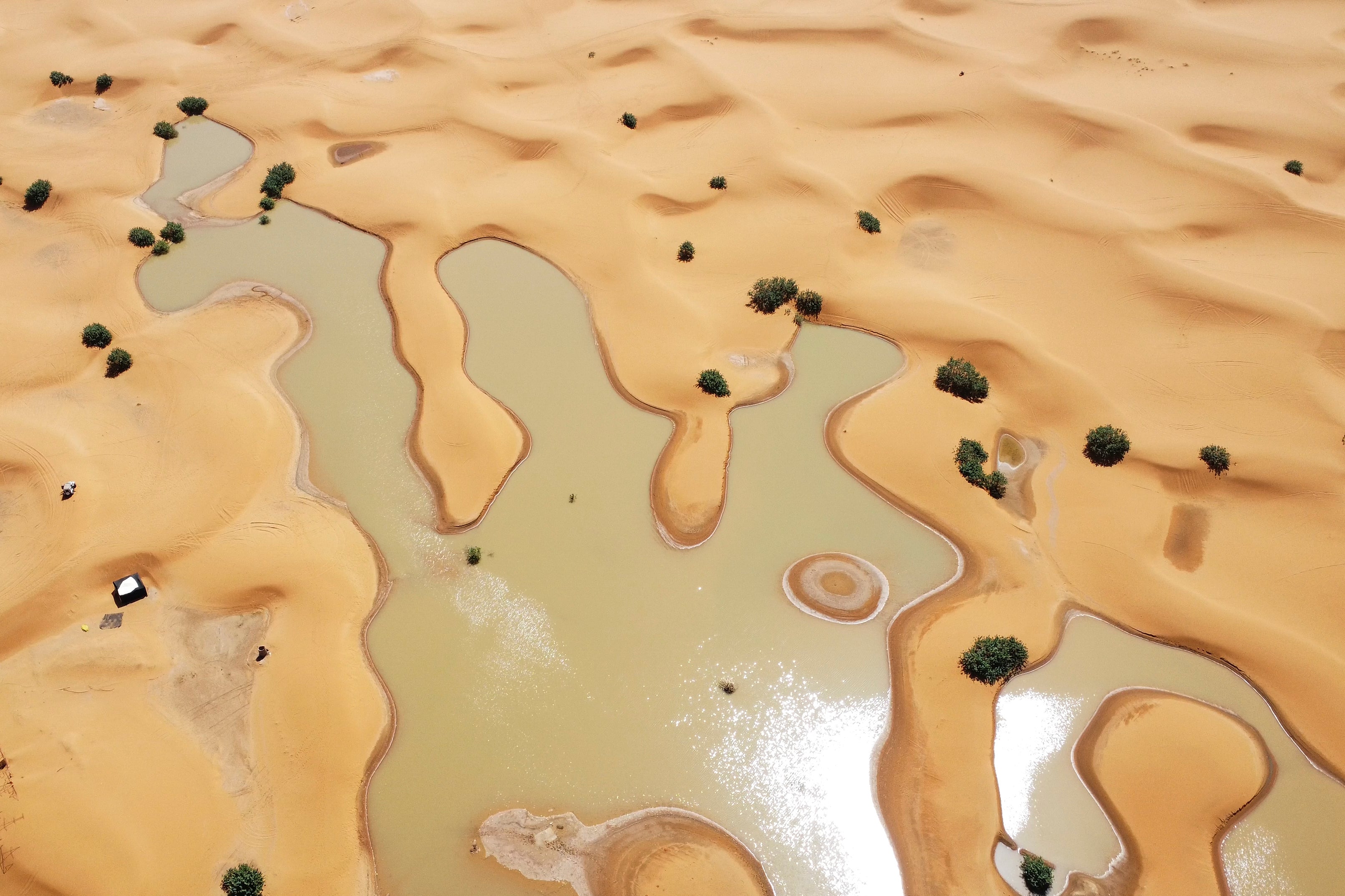 A view of lakes caused by heavy rainfall between sand dunes in the desert town of Merzouga, near Rachidia