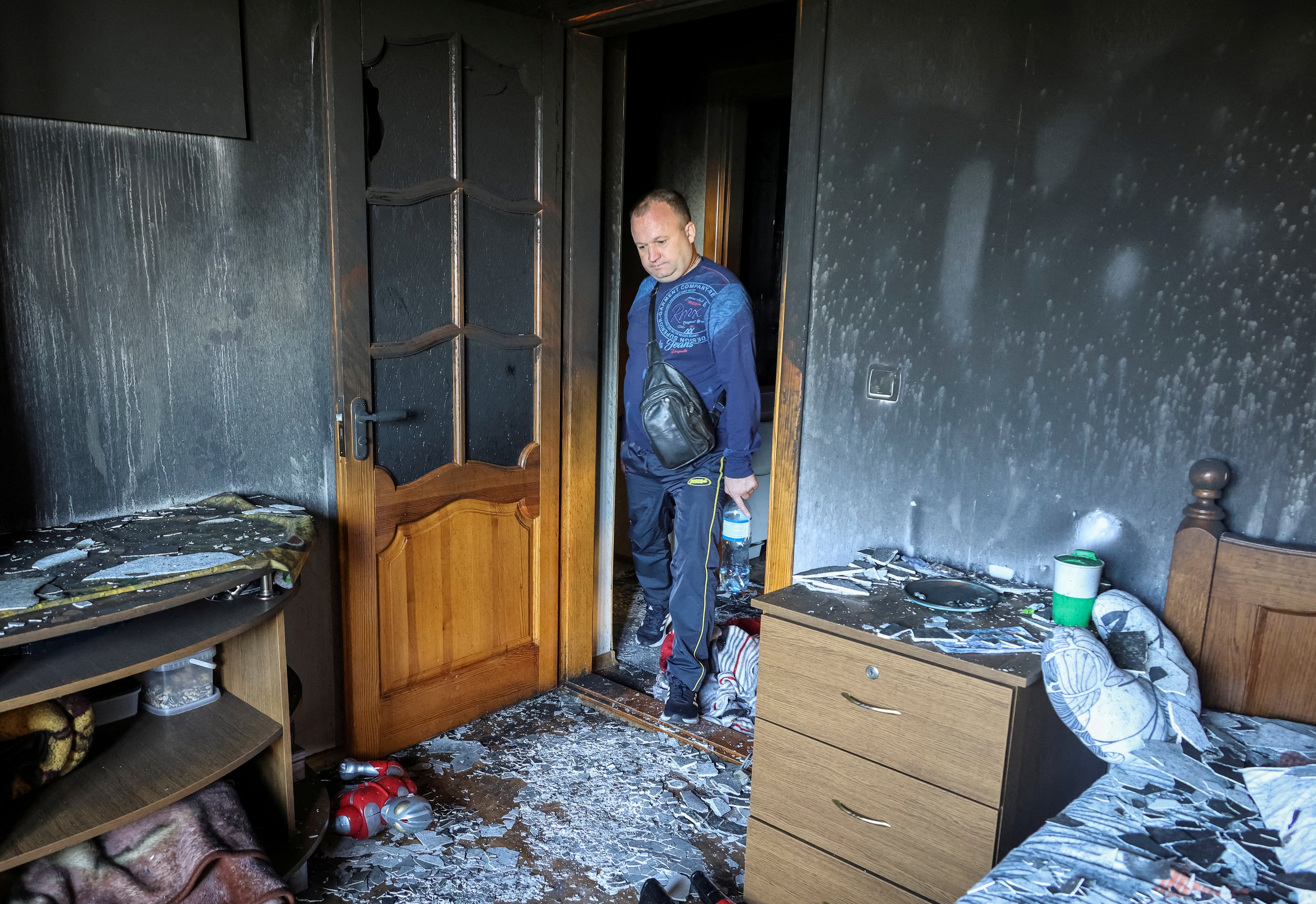 A local looks at the damage in his flat following the Russian strike