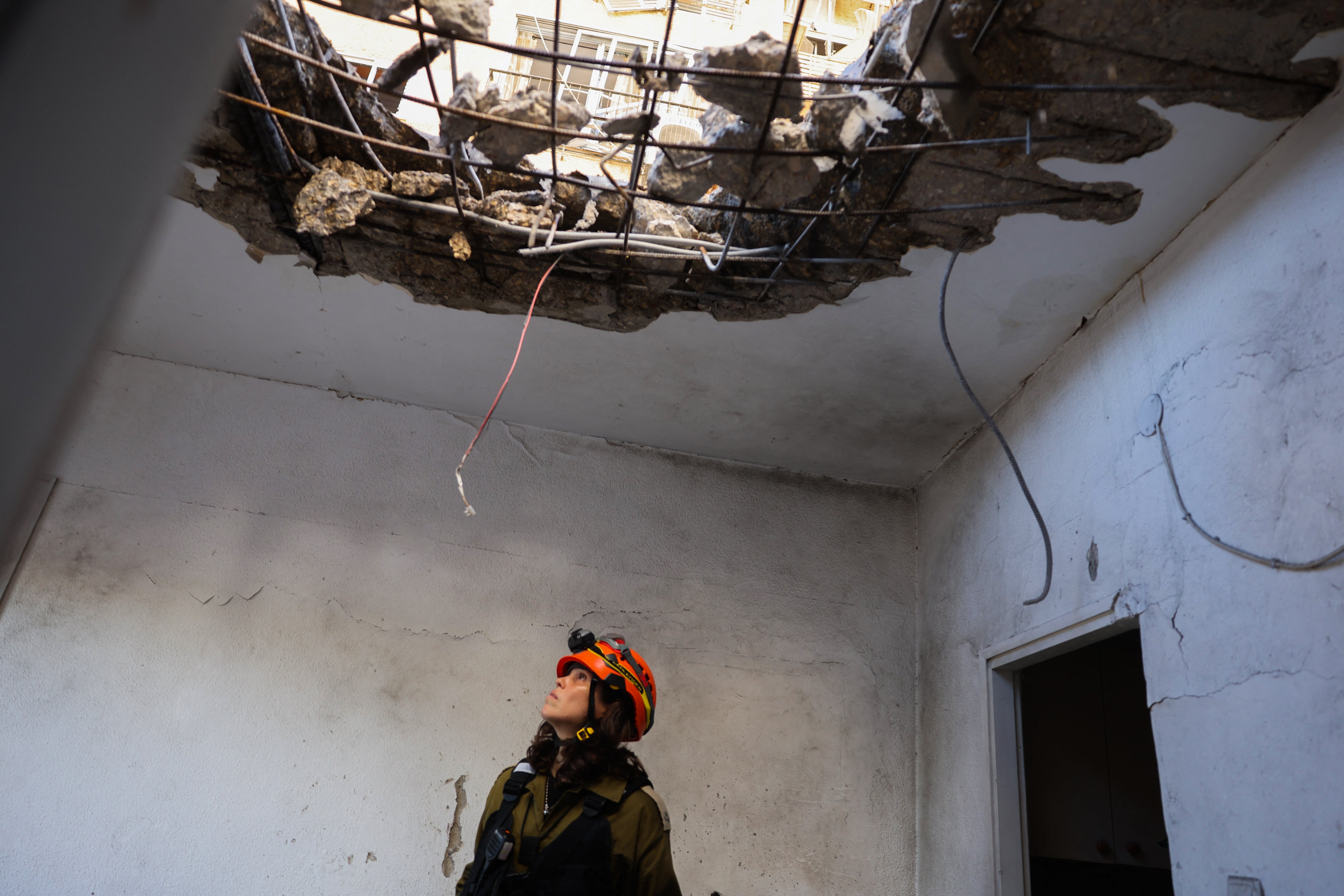 Israeli emergency services inspect damage to a ceiling near Haifa following Hezbollah rocket fire