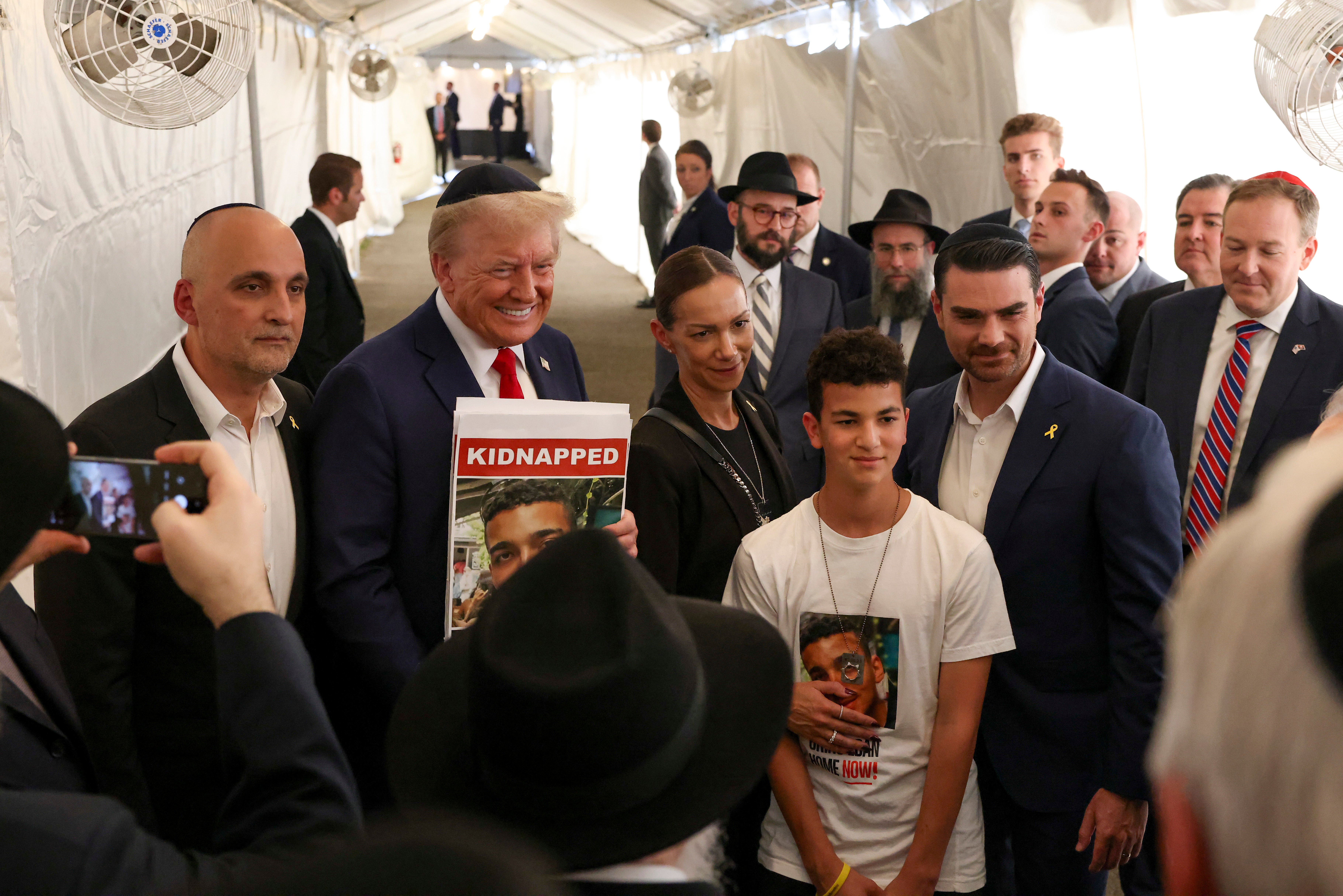 Donald Trump poses for photos with family members of Edan Alexander, a hostage held by Hamas, after visiting the gravesite of Rabbi Menachem Mendel Schneerson