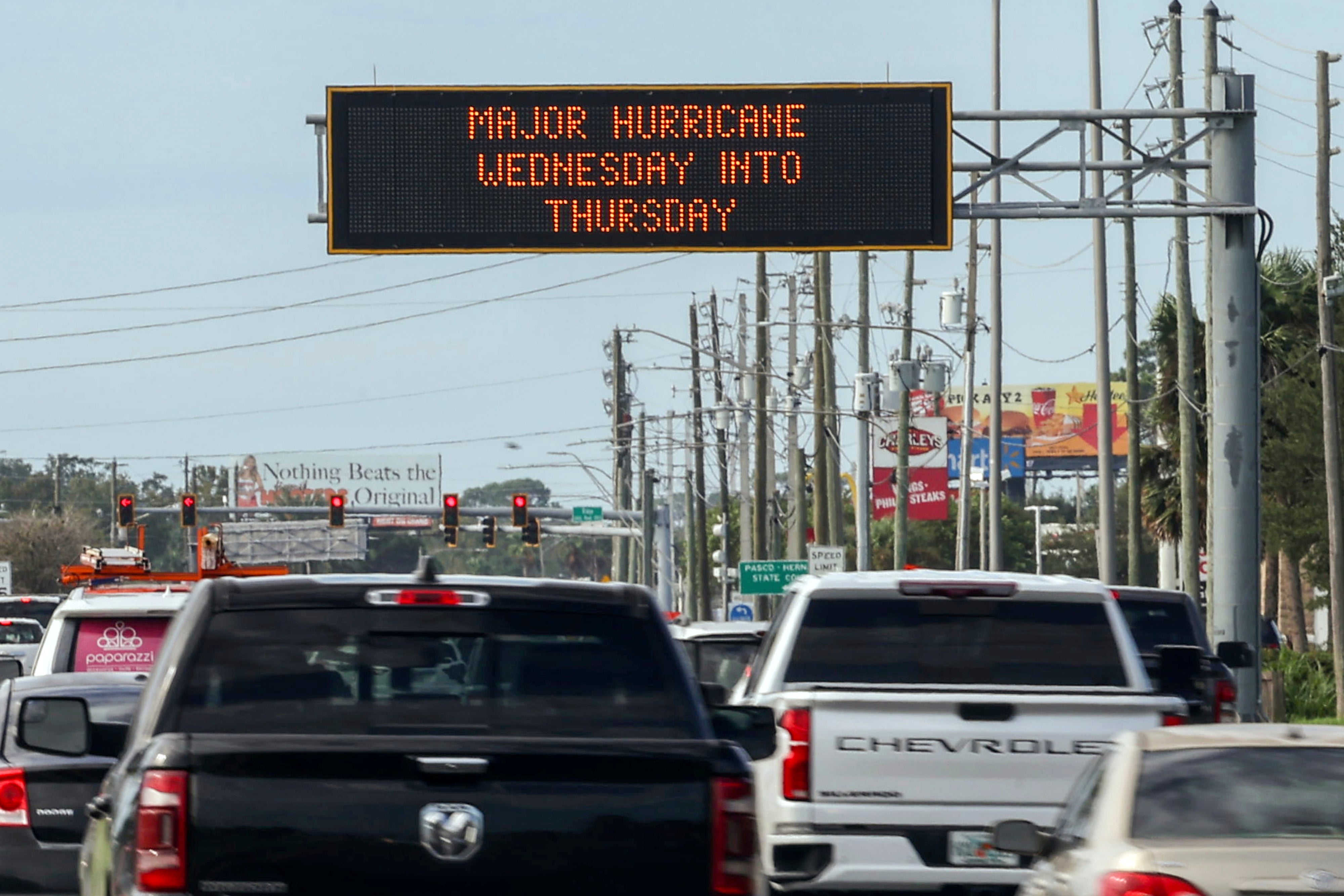 Highway signage announces the impending arrival of Hurricane Milton and the evacuations zones Tuesday in Port Richey, Florida. Additional lanes were opened to ensure people could leave.