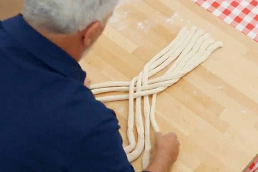 Paul Hollywood demonstra como trançar massa durante um episódio de 'The Great British Bake Off'