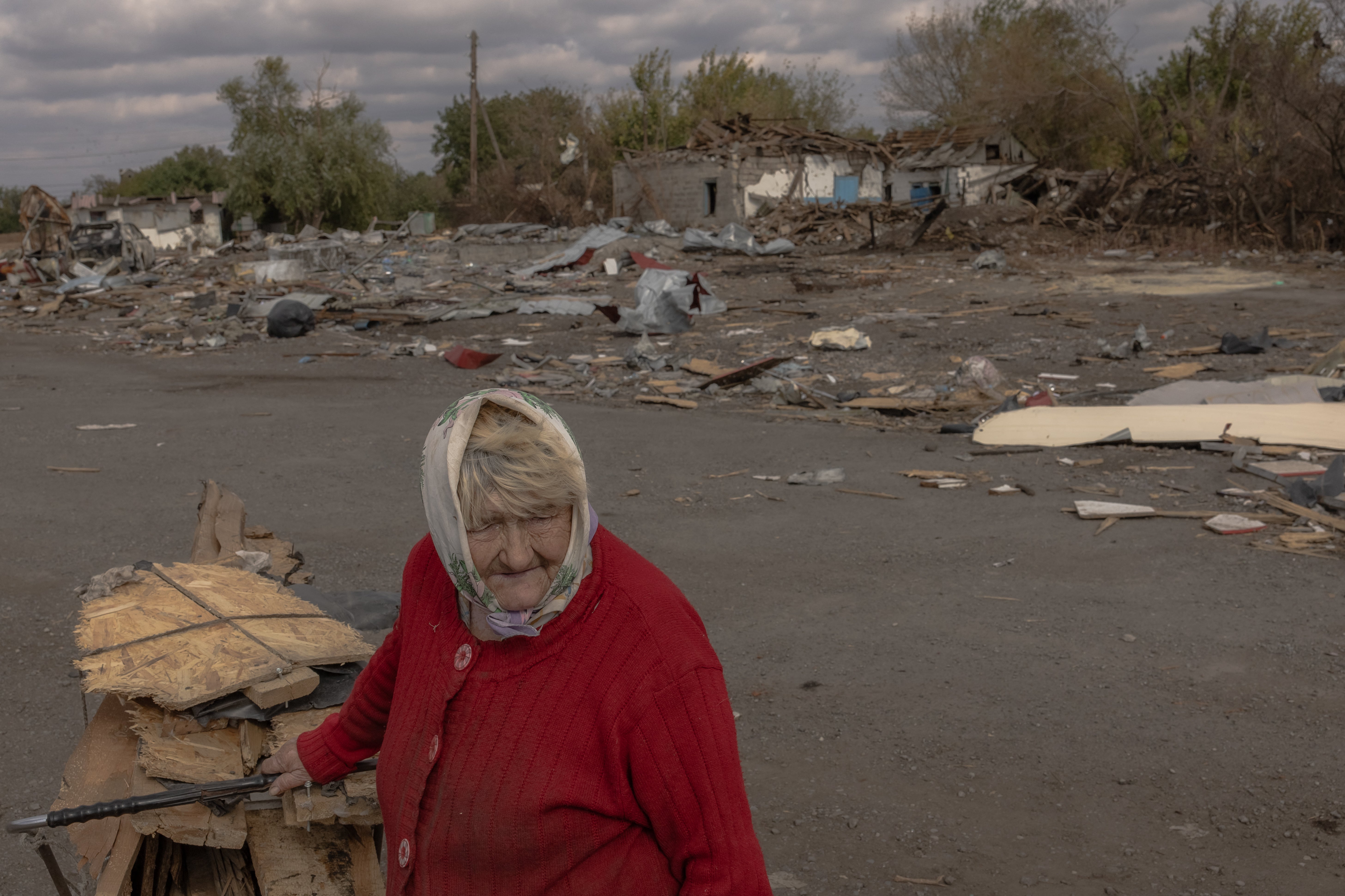 An elderly woman collects wood ahead of the winter in an area recently shelled in the village of Yasenove, south of the city of Pokrovsk, Donetsk region