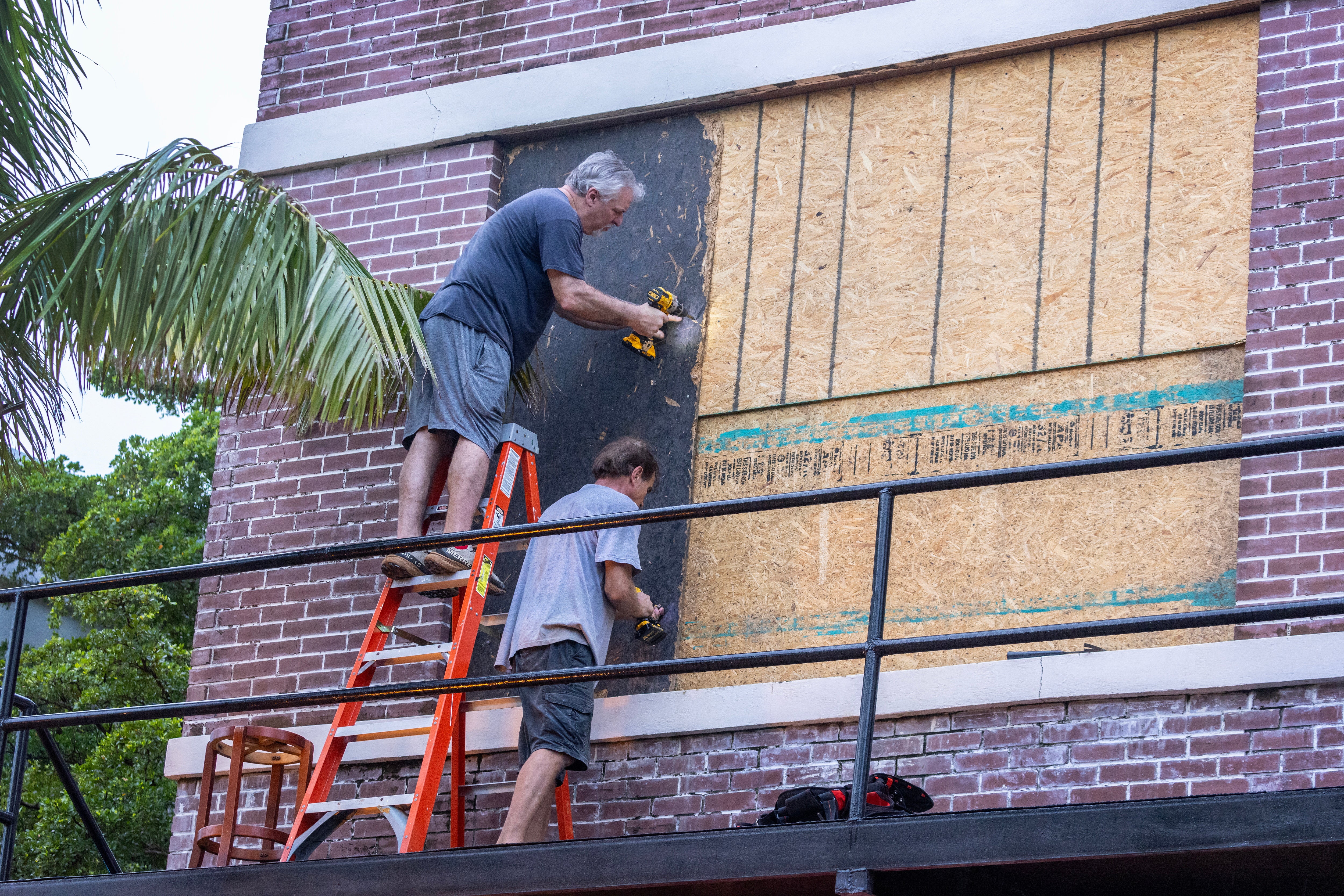 Fort Myers residents place plywood over second floor windows as they prepare for Hurricane Milton