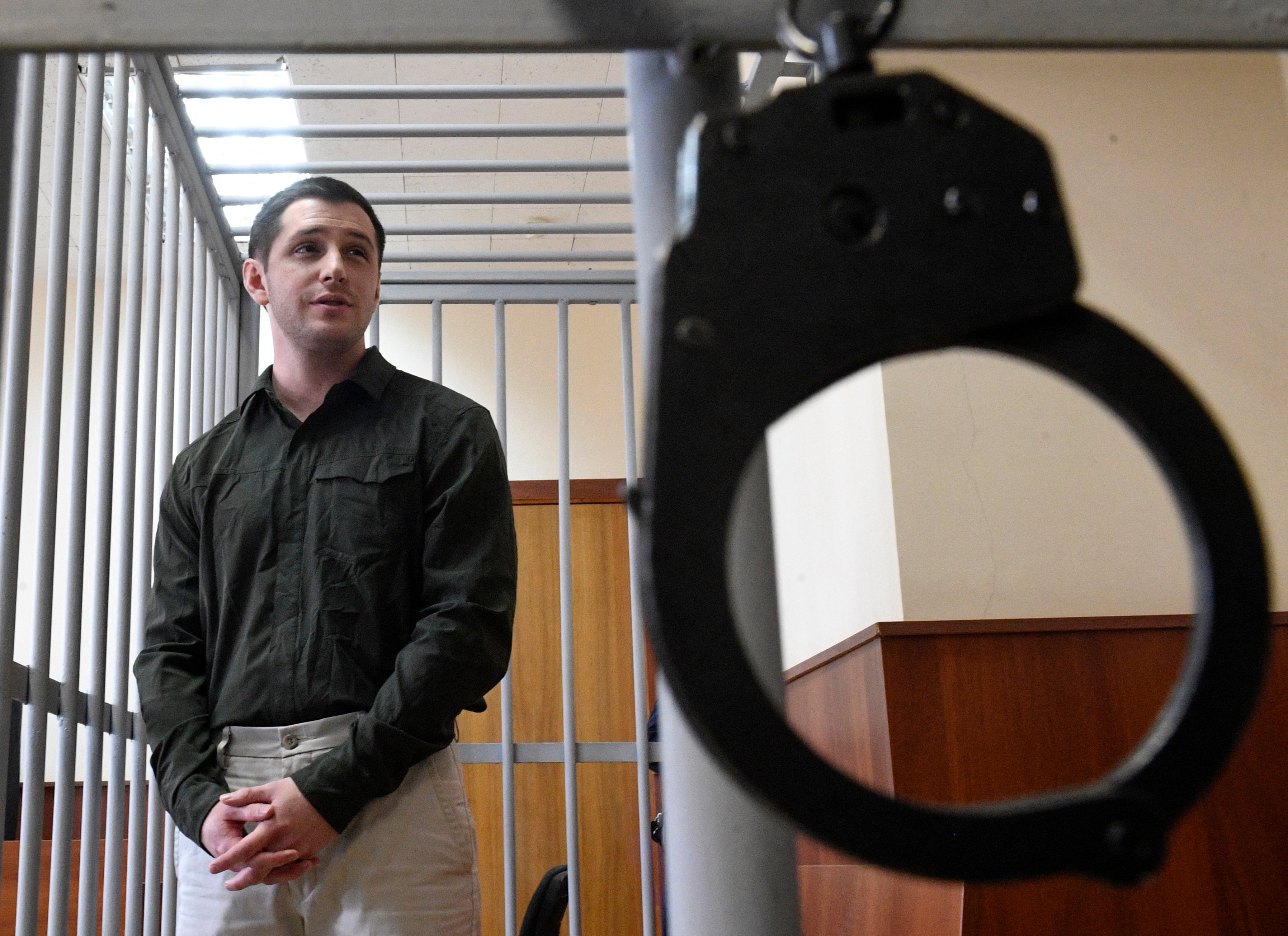 Former U.S. Marine Trevor Reed, accused of attacking police, stands in a defendant's cage during a court hearing in Moscow, March 11, 2020