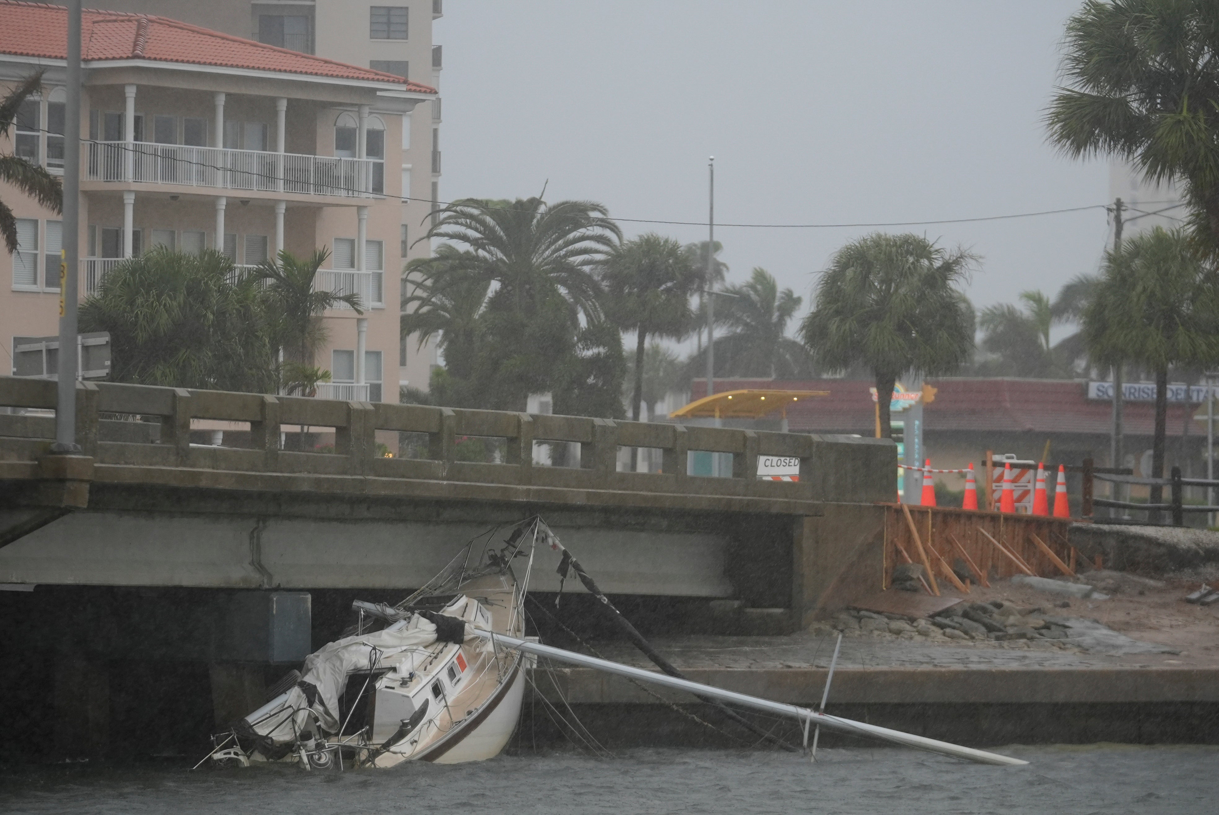 A boat damaged in Hurricane Helene rests against a South Pasadena, Florida, bridge ahead of the arrival of Hurricane Milton on Wednesday.