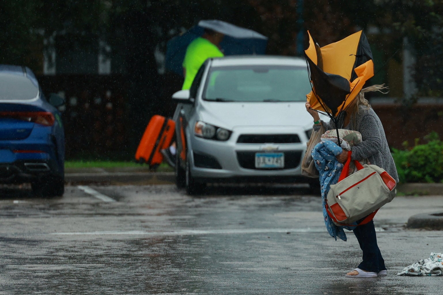 A woman struggles to hold an umbrella while arriving at a shelter in Lakeland, Florida, on Wednesday.