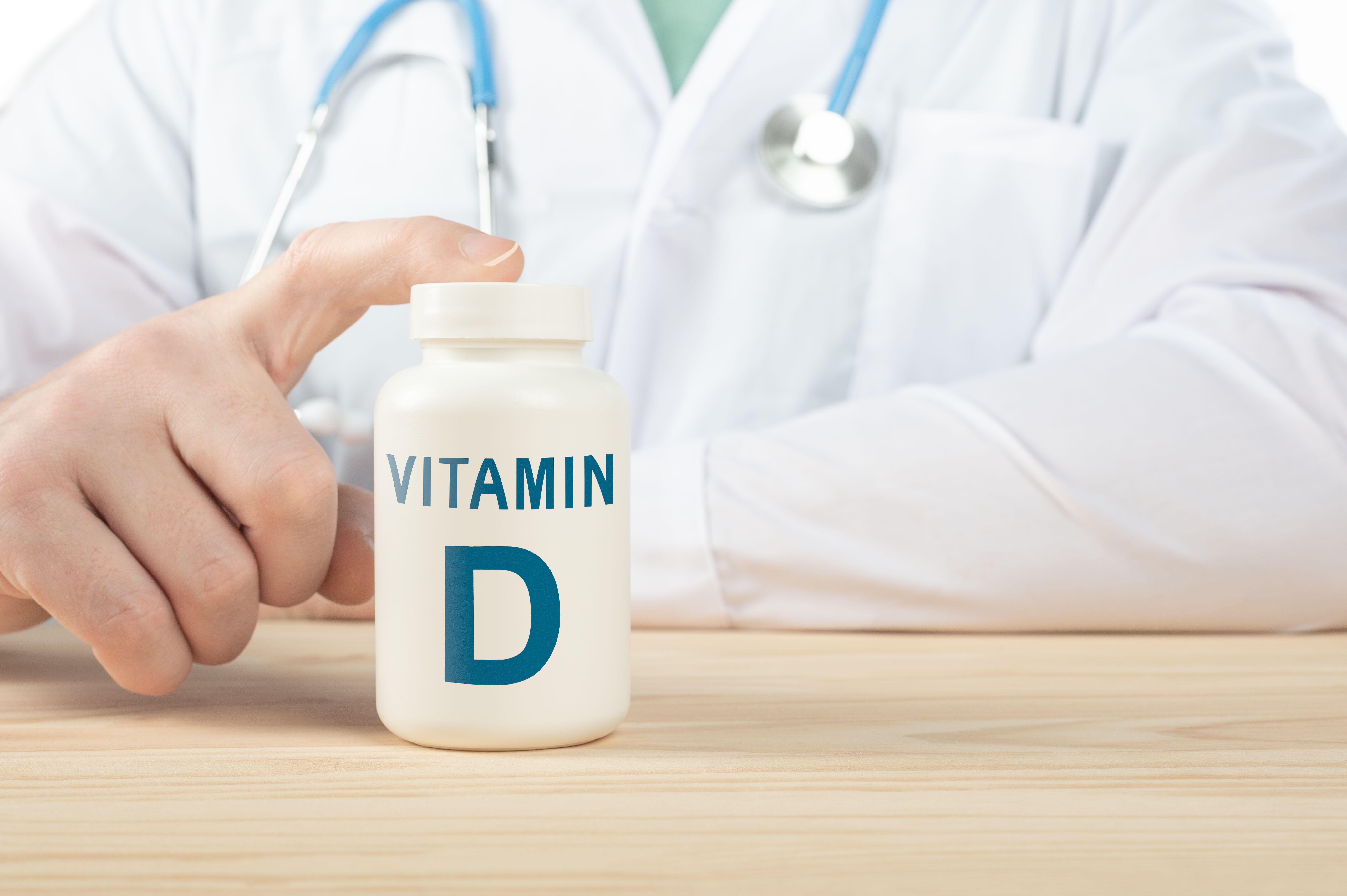 Close up photo of doctor next to a box of vitamin D tablets (Alamy/PA)