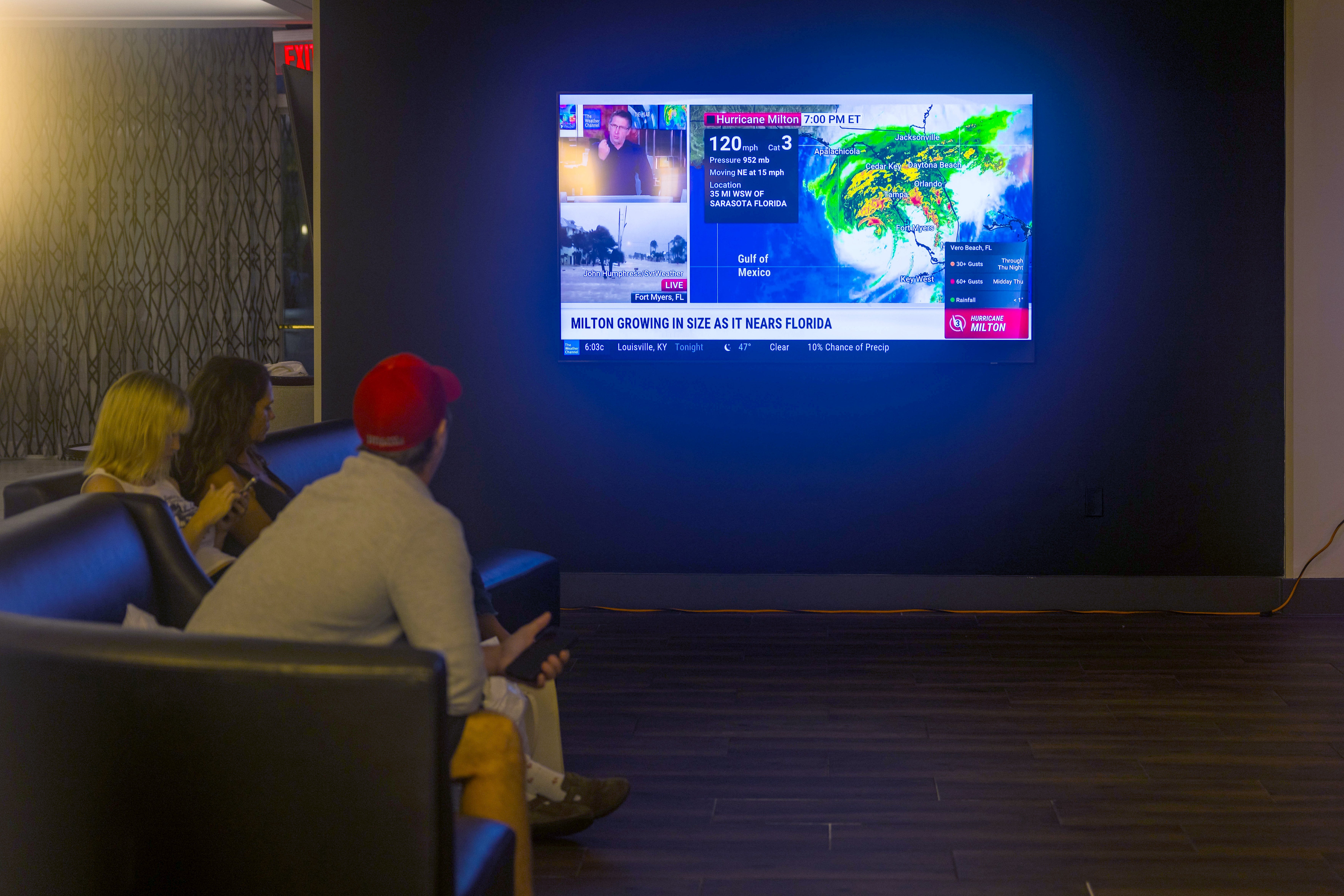 People watch the weather at a restaurant in Orlando, Florida, on October 9. State officials had pleaded for days for people to evacuate. More than 3 million people were under evacuation orders in the Tampa Bay area alone. Many chose to leave but a few stayed and decided to brave the storm