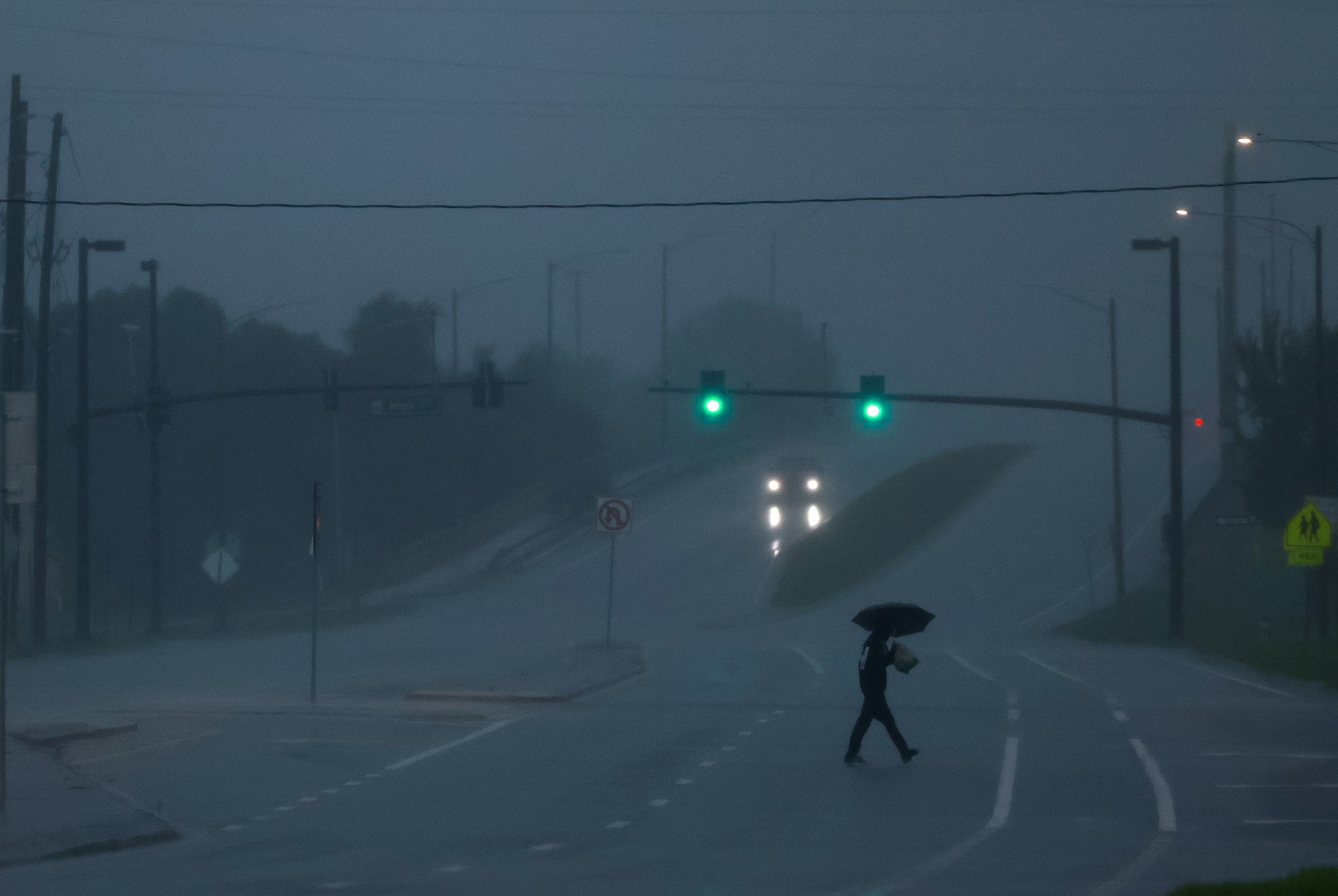 A man walks down a street holding an umbrella and heavy wind and rain start to pour into Orlando. At one point, Milton packed 180 mph winds, which was only one of nine Atlantic storms ever to do so. By the time it started to impact Florida, wind gusts of 120mph were reported