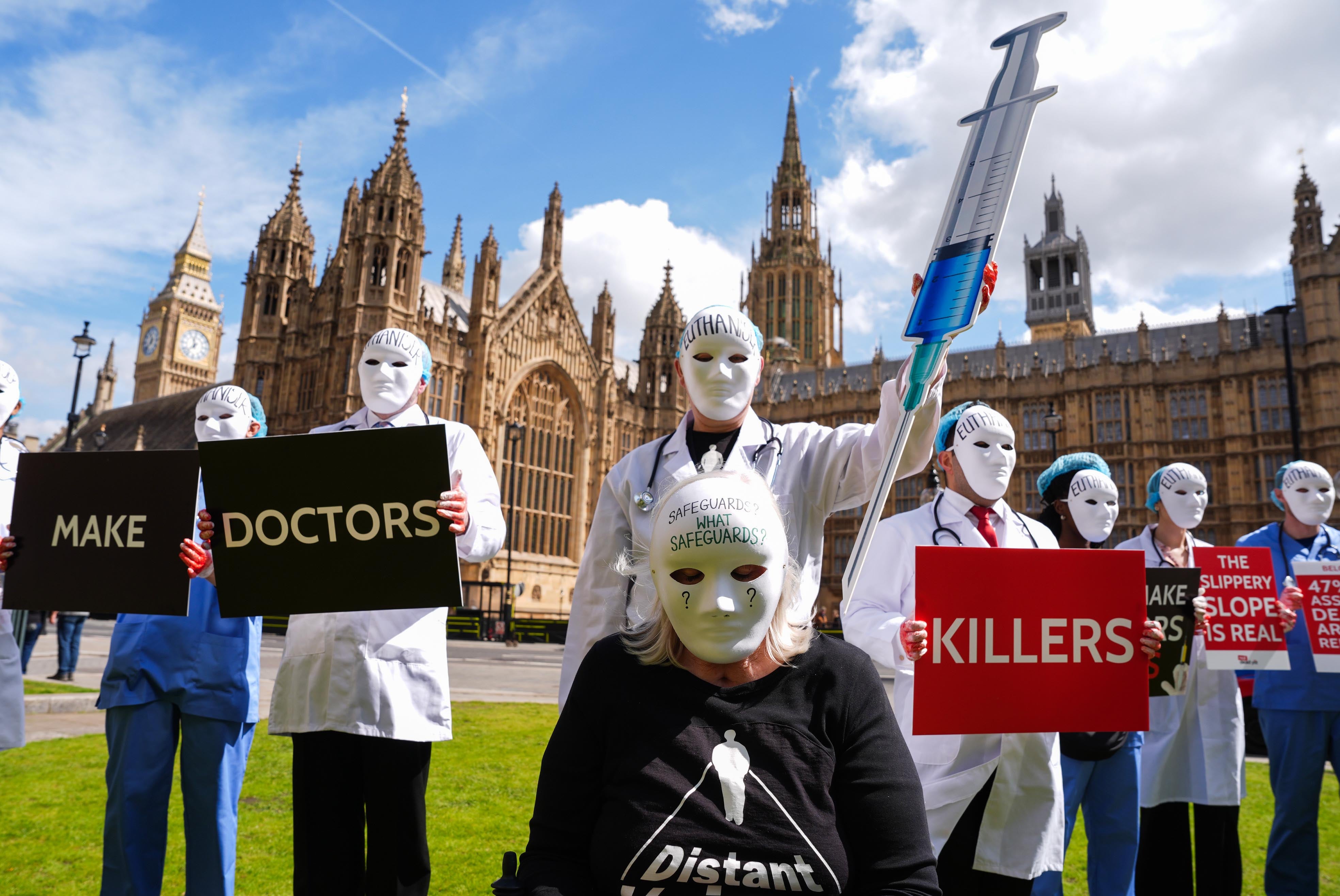 People in masks at an assisted dying protest at Parliament