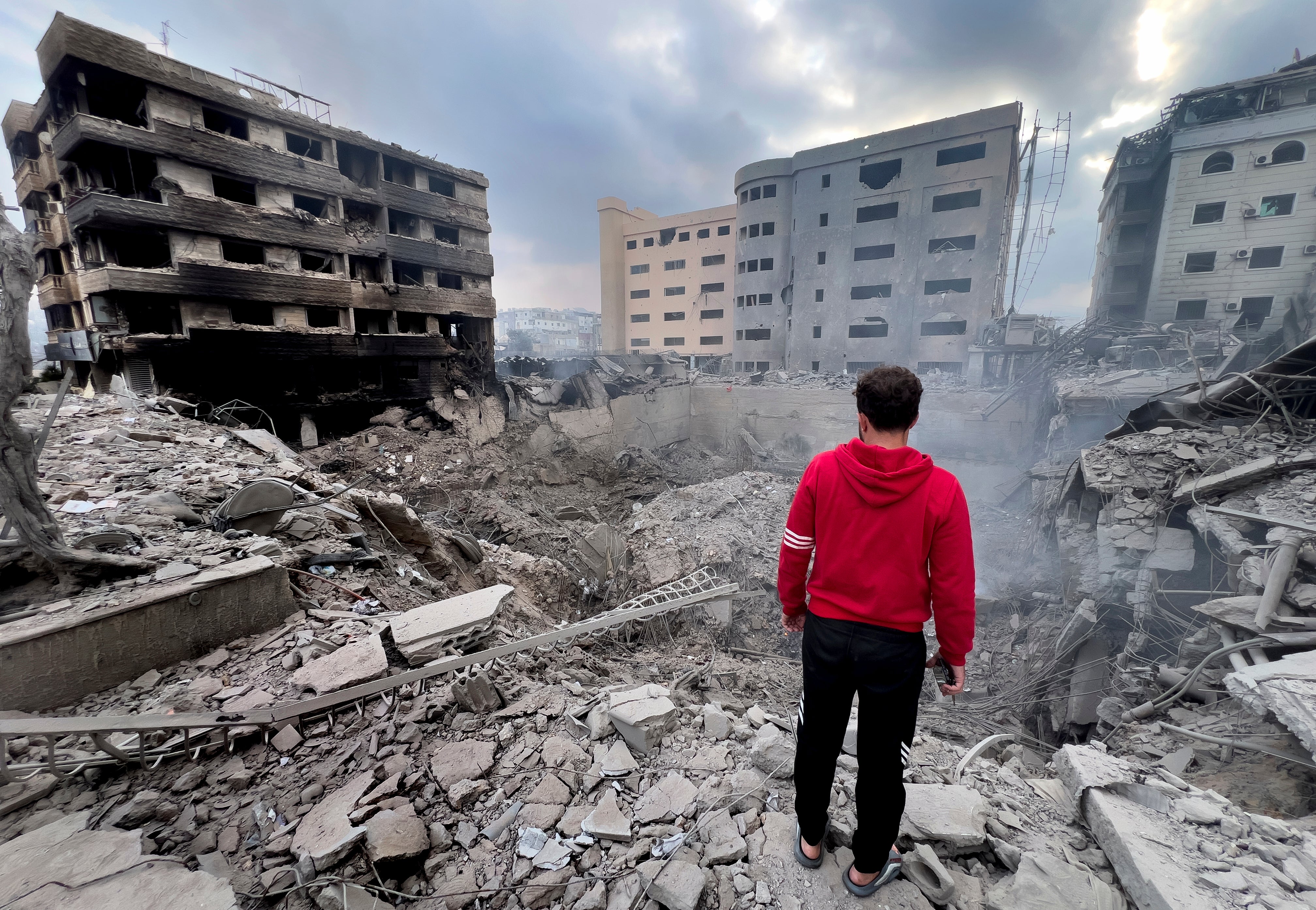 A man looks at destroyed buildings hit by Israeli airstrikes in Dahiyeh, Beirut, Lebanon