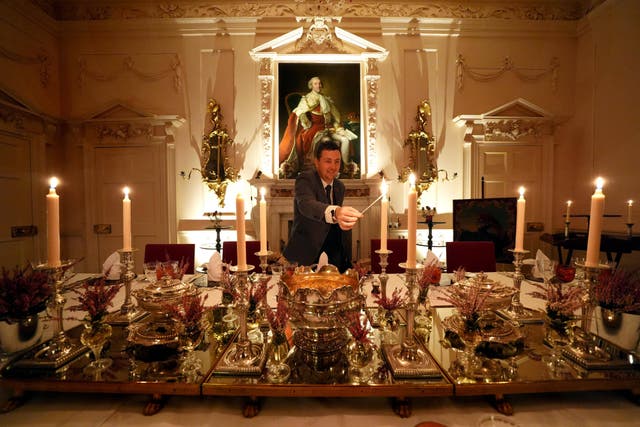 Evan Samson, who leads the front of house team at Dumfries House, lights candles as he puts the finishing touches to the Pink Dining Room – the King’s favourite room at Dumfries House in Cumnock, Ayrshire (Andrew Milligan/PA)