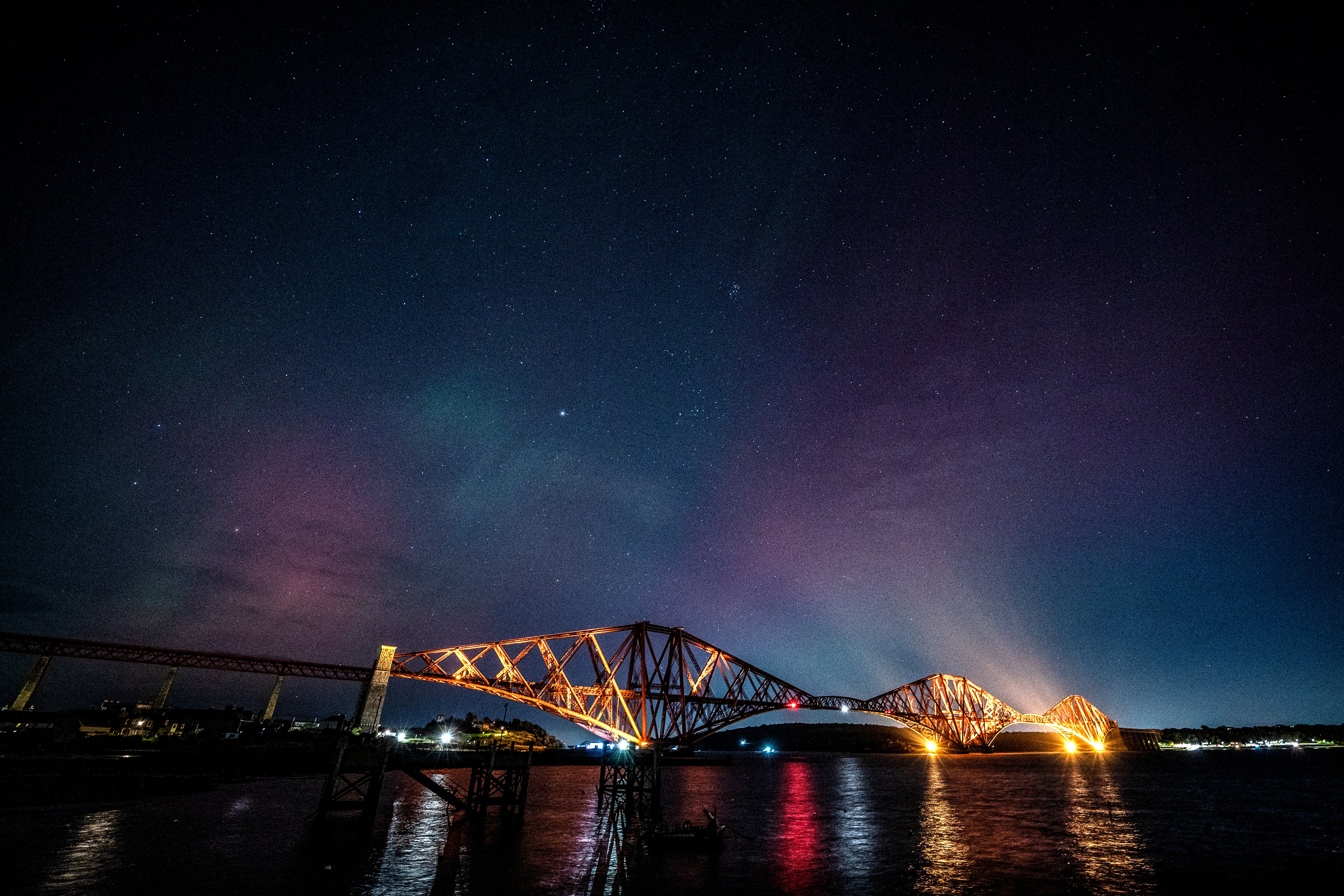 The Northern Lights visible above the Forth Bridge, North Queensferry in Fife