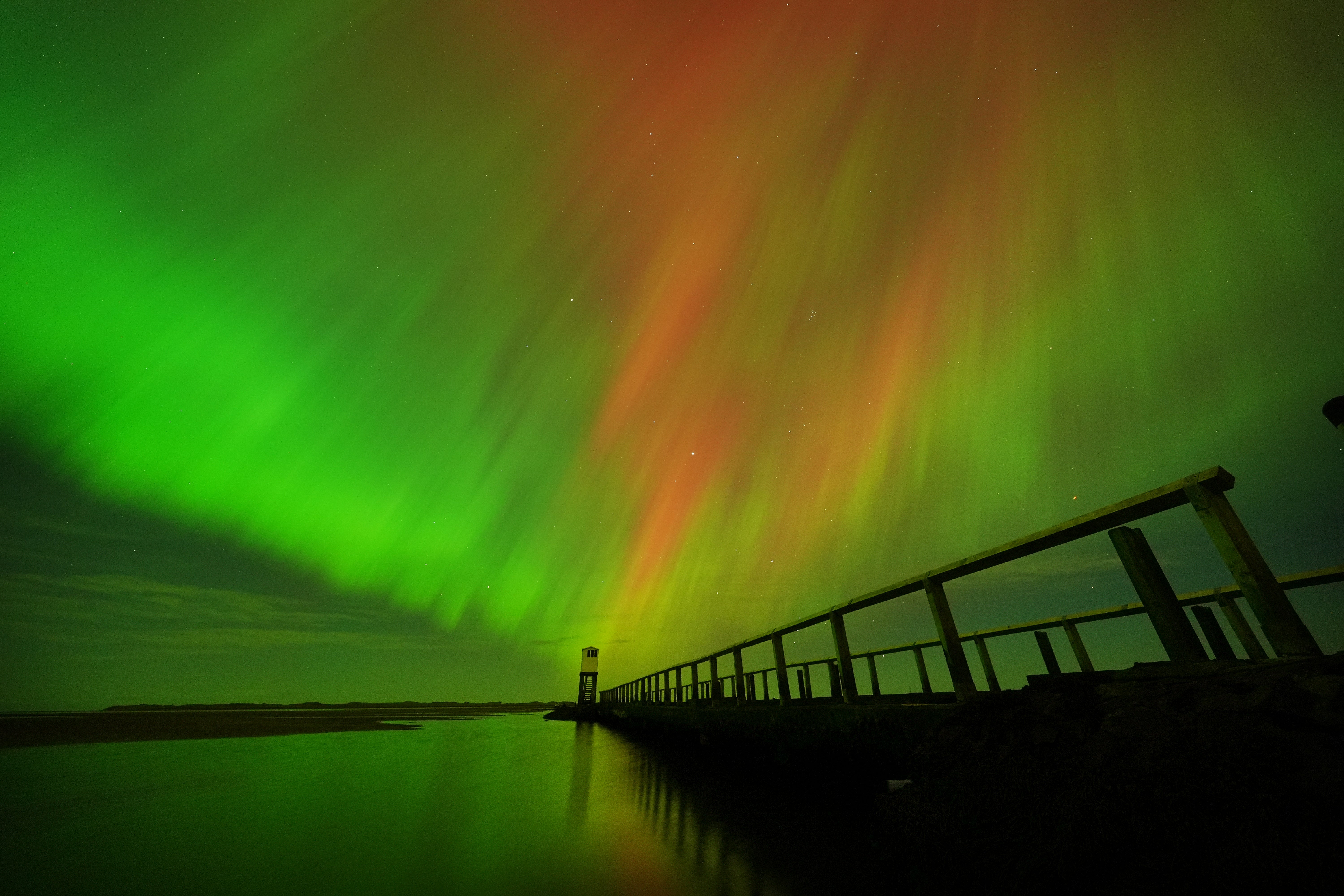 <p>Aurora displays occur when charged particles collide with gases in the Earth’s atmosphere around the magnetic poles (Owen Humphreys/PA)</p>