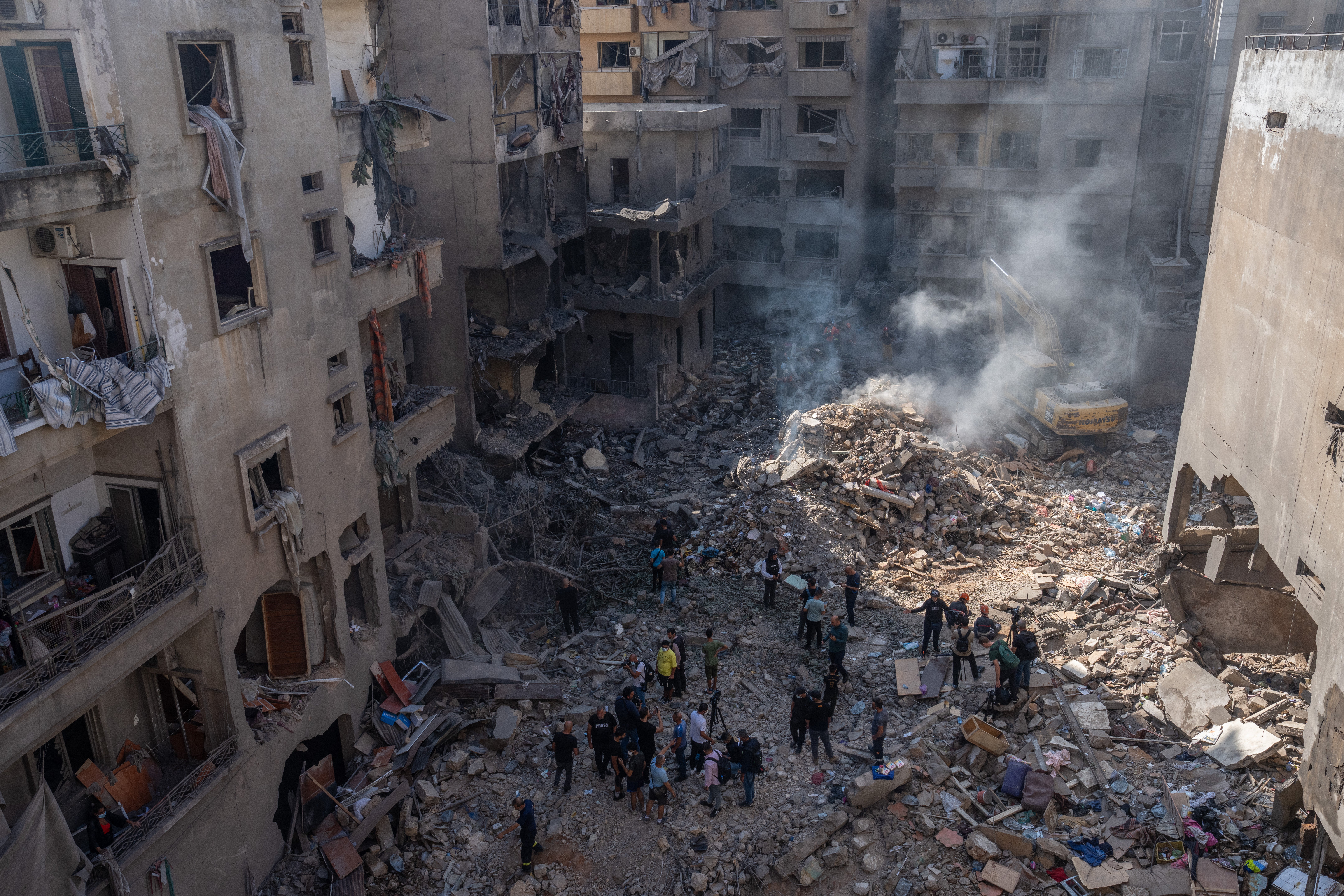 Rescue workers and members of the media work at the site of an Israeli airstrike on apartment block in Beirut, Lebanon